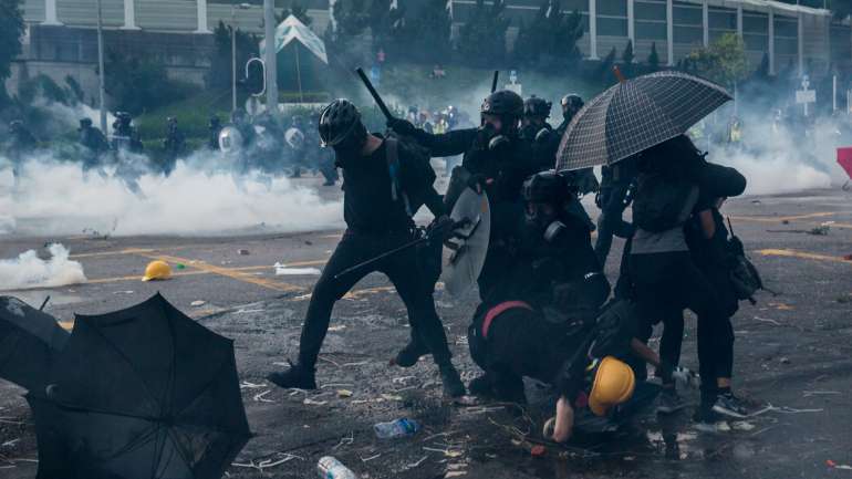 Manifestantes pró-democracia queimam cartão nas ruas para erguer uma barricada