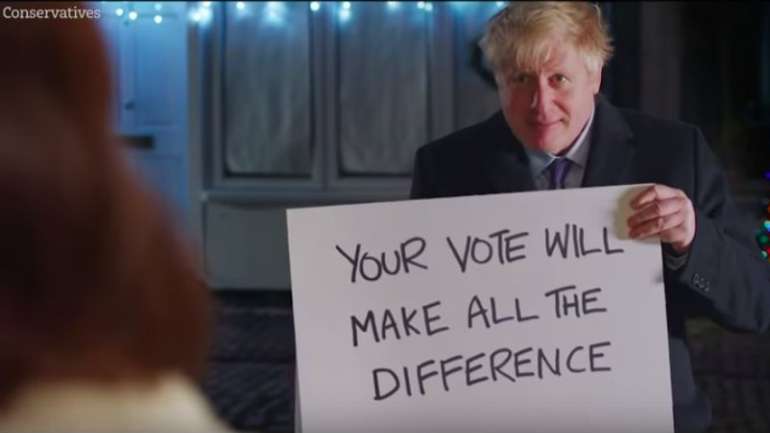 Na versão original a cena dos cartões serve para fazer uma declaração de amor. A dois dias das eleições, Johnson pediu o que lhe faz mais falta: votos