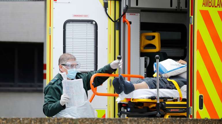 Um paramédico transporte um paciente de COVID-19 para um hospital em Londres