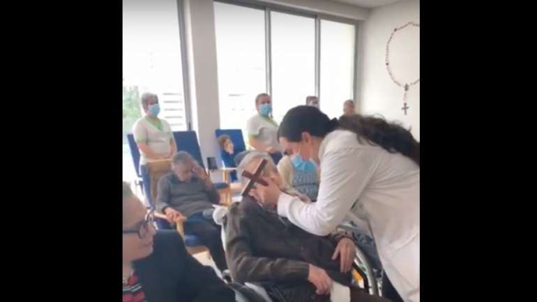 Nas imagens, divulgadas pelo Semanário V, é possível ver vários idosos beijar o mesmo crucifixo