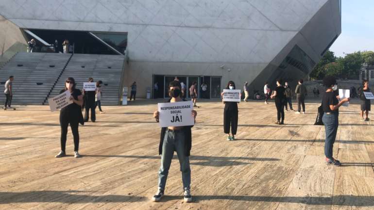 Vestidos de preto, de máscara no rosto, em silêncio e a segurar cartazes com trocadilhos e expressões de luta. Assim se apresentaram os mais de 20 trabalhadores dispensados das duas instituições