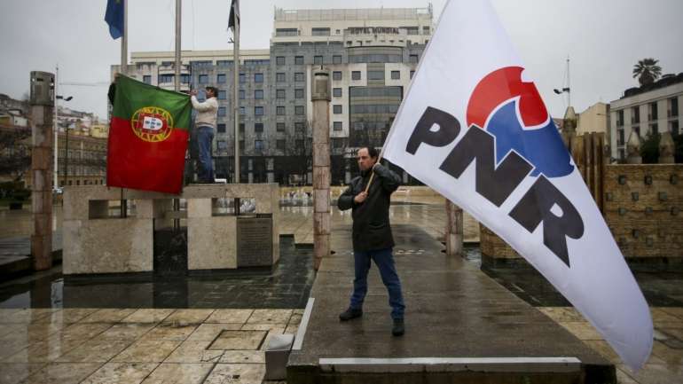 A sigla PNR transformou-se em “E” e o símbolo do partido é a palavra “Ergue-te” a azul com uma chama vermelha no hífen