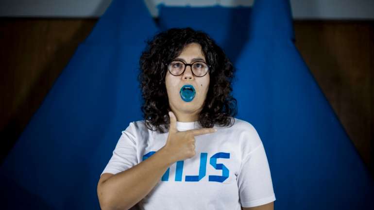 “Come com os olhos. Morde com o nariz. Emprenha pelos ouvidos. Fala pelos cotovelos”, lê-se no cartaz do espetáculo “Língua”
