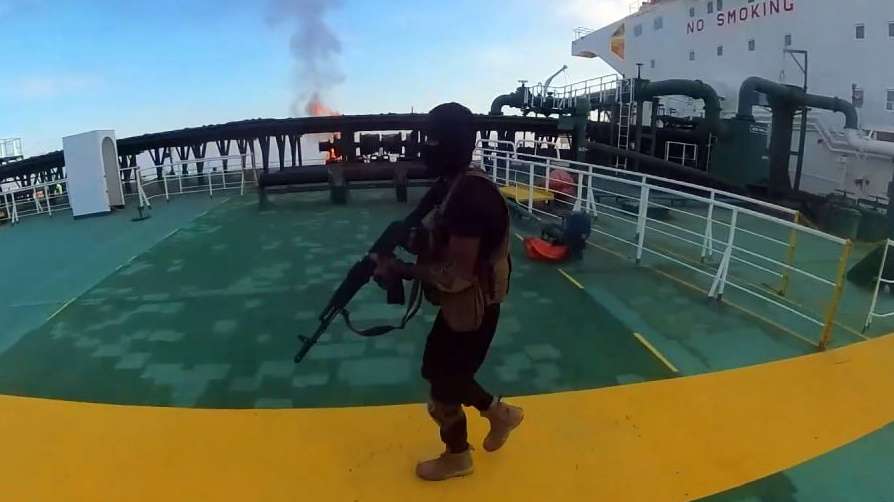 epa11572344 A handout photo made available by the Houthis media center shows a masked Houthi fighter with a rifle boarding the Greek-flagged oil tanker Sounion following Yemen's Houthis attacks, in the Red Sea, 29 August 2024. Yemen's Houthis have agreed to allow tugboats and rescue ships to access the damaged crude oil tanker Sounion in the Red Sea a week after they attacked it, according to a statement by Houthi spokesperson Muhammad Abdul-Salam. The Greek-flagged oil tanker Sounion, which has been on fire since 23 August in the Red Sea following Yemen's Houthis attacks, is still burning and it appears to be leaking oil, a US Pentagon spokesman said. Yemen's Houthis have claimed responsibility for a two-small boats and three projectiles attack against the oil tanker Sounion in the Red Sea off Yemen on 21 August 2024, Houthi military spokesman Yahya Sarea said in a statement.  EPA/HOUTHIS MEDIA CENTER HANDOUT -- BEST QUALITY AVAILABLE -- 

HANDOUT EDITORIAL USE ONLY/NO SALES