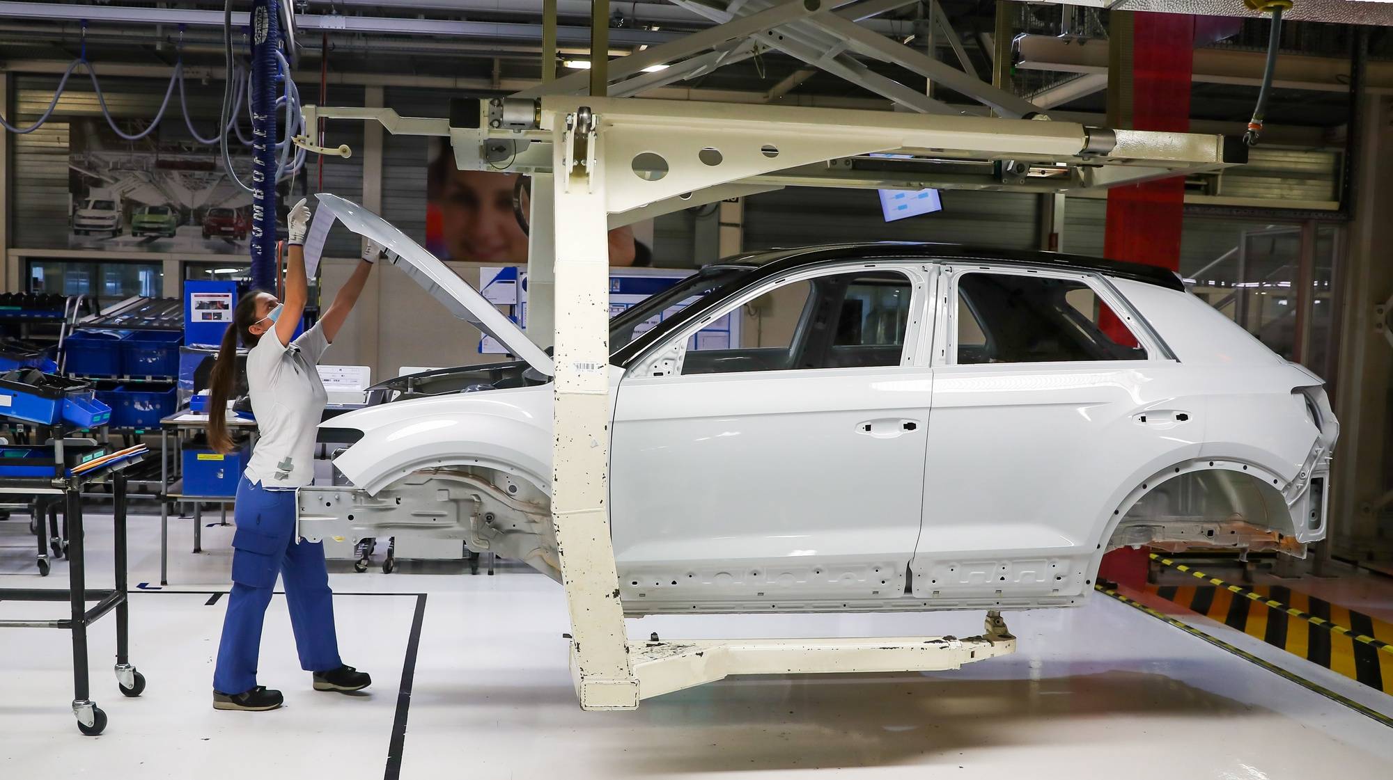 epa08419872 Autoeuropa employees work at the construction line for the Volkswagen T-Roc at Autoeuropa&#039;s plant in Palmela, Setubal, Portugal, 13 May 2020.  EPA/JOSE SENA GOULAO