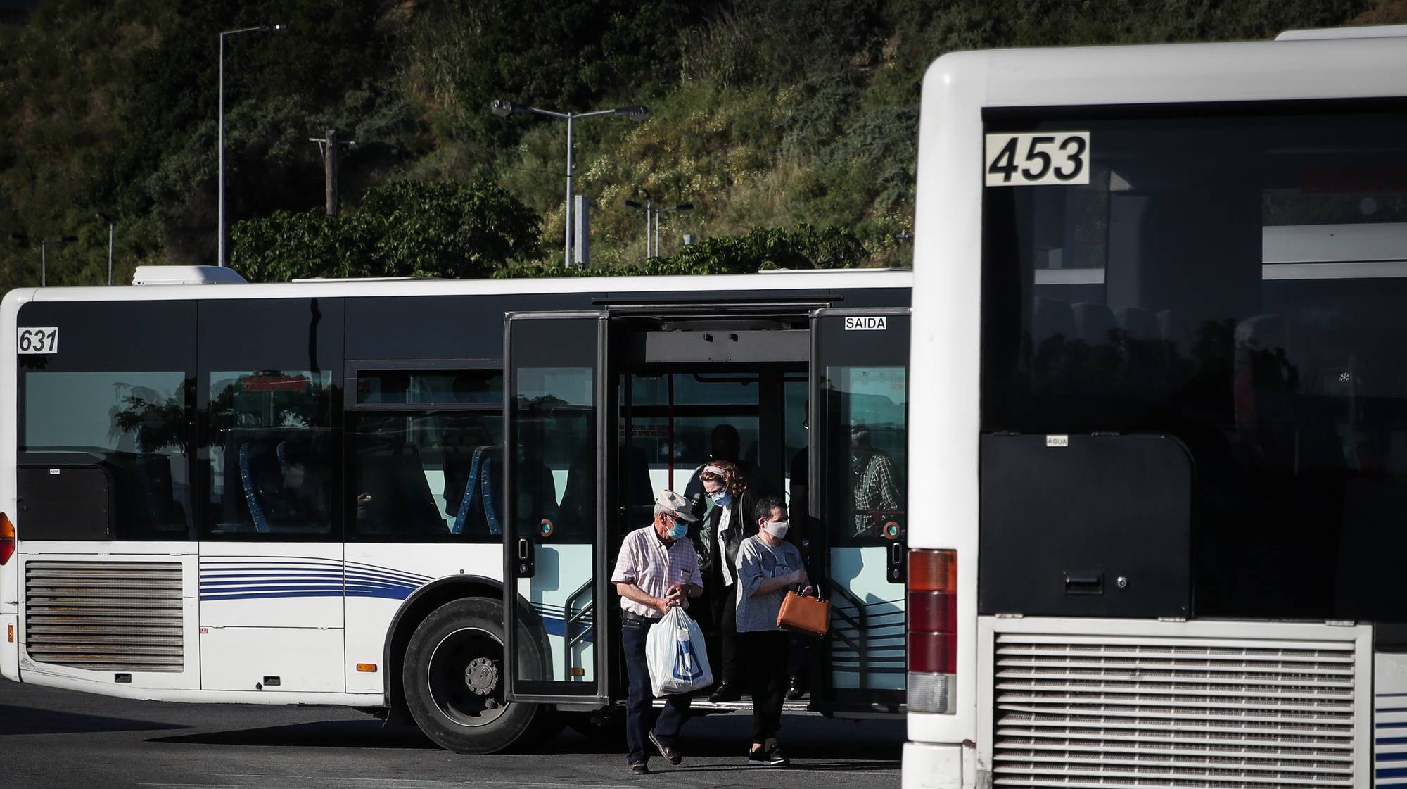 Utentes à saída de um autocarro dos Transportes Sul do Tejo (TST), em Cacilhas, Almada, 20 de maio de 2020. O transporte rodoviário foi reforçado com a entrada do segunda fase do desconfinamento devido à pandemia da covid-19, apesar disso as carreiras continuam com poucas pessoas o que contrasta com a grande utilização dos transportes fluviais da Transtejo/Soflusa. (ACOMPANHA TEXTO). MÁRIO CRUZ/LUSA