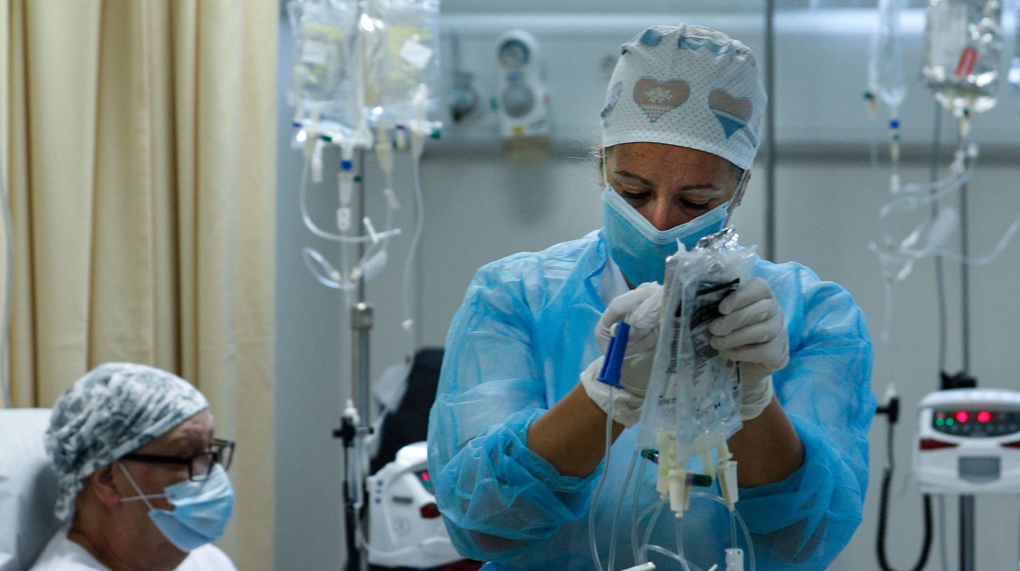 Uma profissional de saúde presta cuidados a uma utente do serviço oncológico durante uma sessão de tratamento no Hospital Distrital de Santarém, que manteve a sua atividade, apesar das alterações realizadas na unidade hospitalar para receber doentes covid-19, em Santarém, 21 de maio de 2020. do dia  23 de maio de 2020. Desde o dia 03 de maio que o país está em estado de calamidade, depois de três períodos consecutivos em estado de emergência desde 19 de março. (ACOMPANHA  TEXTO DA LUSA DO DIA 23 DE MAIO DE 2020). ANTÓNIO COTRIM/LUSA