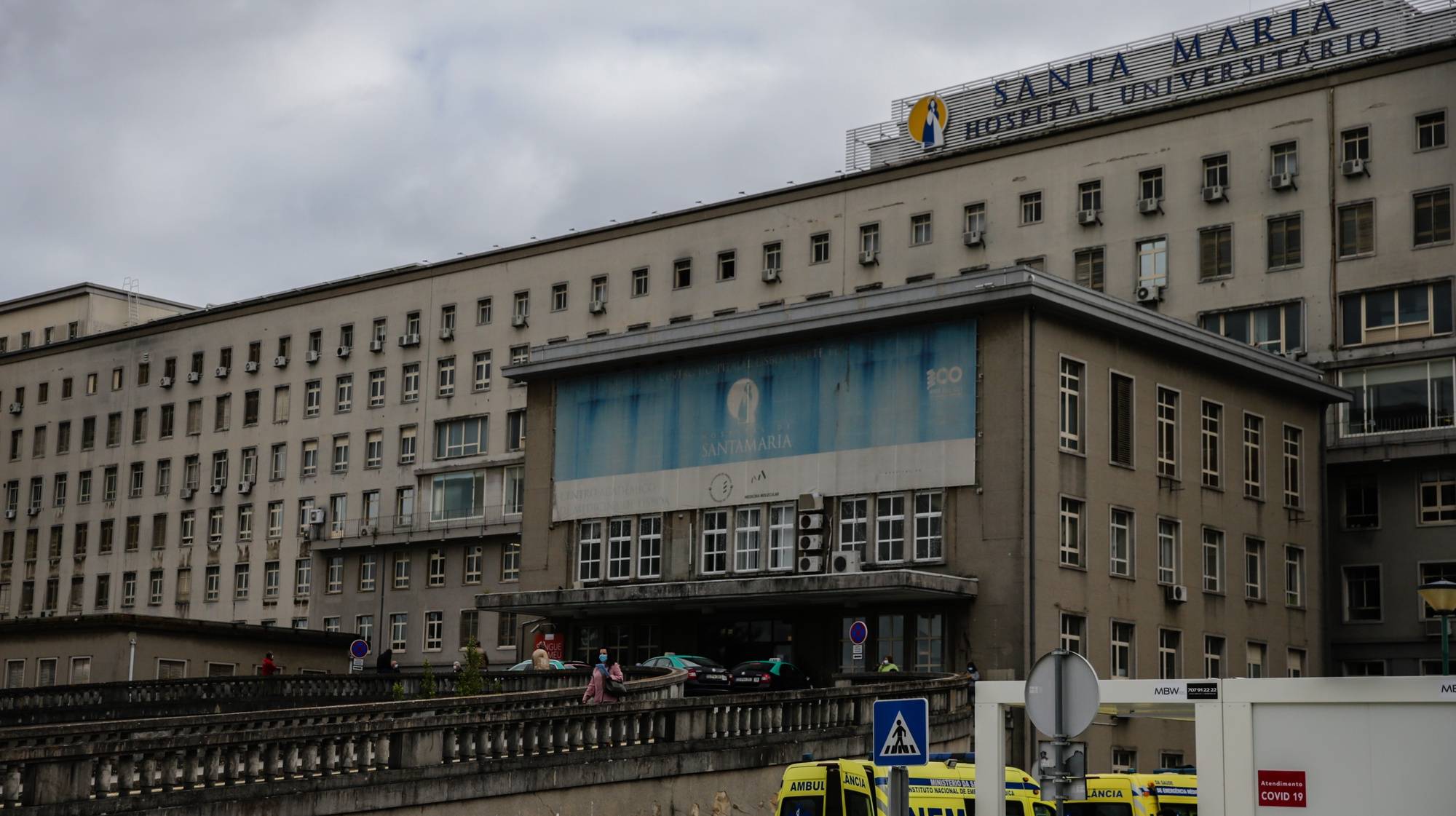 Ambulâncias aguardam na entrada do Hospital Santa Maria em Lisboa, 27 de outubro de 2020. A urgência dedicada aos casos suspeitos de covid-19 do Hospital Santa Maria, em Lisboa, reflete a evolução da pandemia em Portugal com doentes a avolumarem-se à porta para realizar o teste e no interior a capacidade quase esgotada. O medo de perder o emprego leva muitos doentes com covid-19 a esconderem que estão infetados e a continuar a trabalhar, disseminando a doença que, nesta fase, começa a ser um caso também social e que leva a muitos internamentos no Santa Maria. (ACOMPANHA TEXTO DA LUSA DE 30 DE OUTUBRO DE 2020) TIAGO PETINGA/LUSA