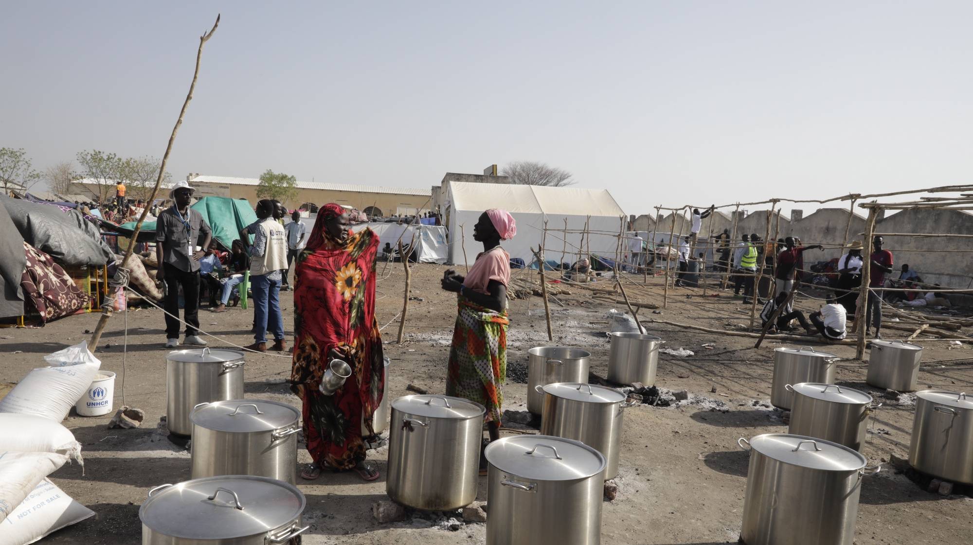 epa10629563 South Sudanese workers of the NGO Goal wait for water to be delivered to prepare meals for returnees, at the transit area set up by the UNHCR in the Upper Nile State town of Renk, South Sudan, 15 May 2023. According to the United Nations, some 200,000 people have fled the conflict in Sudan between 15 April and 12 May 2023. Around 40.000 are in South Sudan, and about two million people were internally displaced. Leaving behind them the armed conflict between the Sudanese military and the RSF (Rapid Support Forces) militia which started one month ago today, most of the refugees in South Sudan are South Sudanese returnees, part of the some 800,000 who had previously fled the war in South Sudan and who are now returning to a country which is barely out of conflict itself, with tensions still remaining in many areas.  EPA/AMEL PAIN