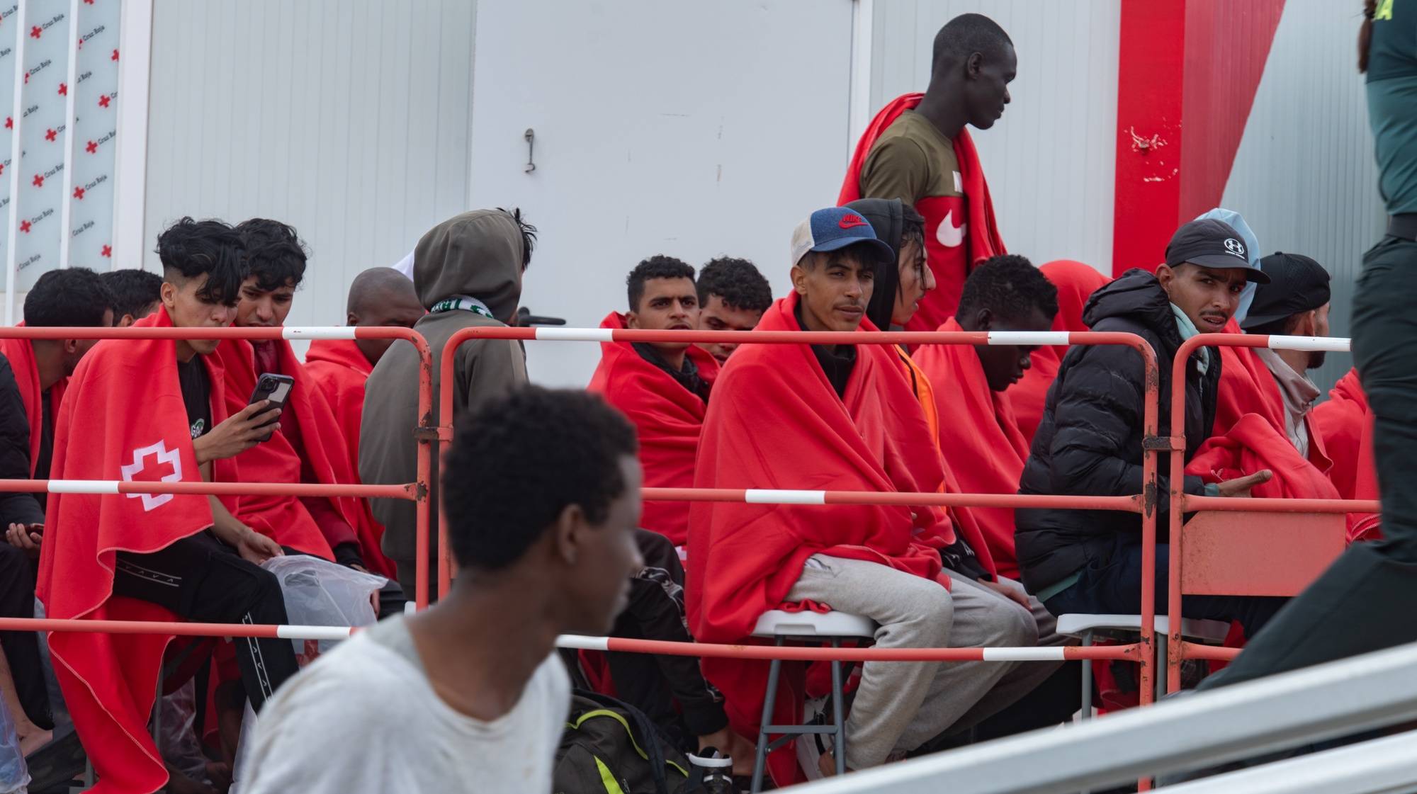 epa11506600 Migrants have a rest shortly after they arrived in an inflatable boat on the coast of Gran Tarajal, Fuerteventura, Canary Islands, Spain, 29 July 2024. A group of 63 migrants, including three women, arrived in an inflatable boat on the coast of Fuertaventura.  EPA/CARLOS DE SAA