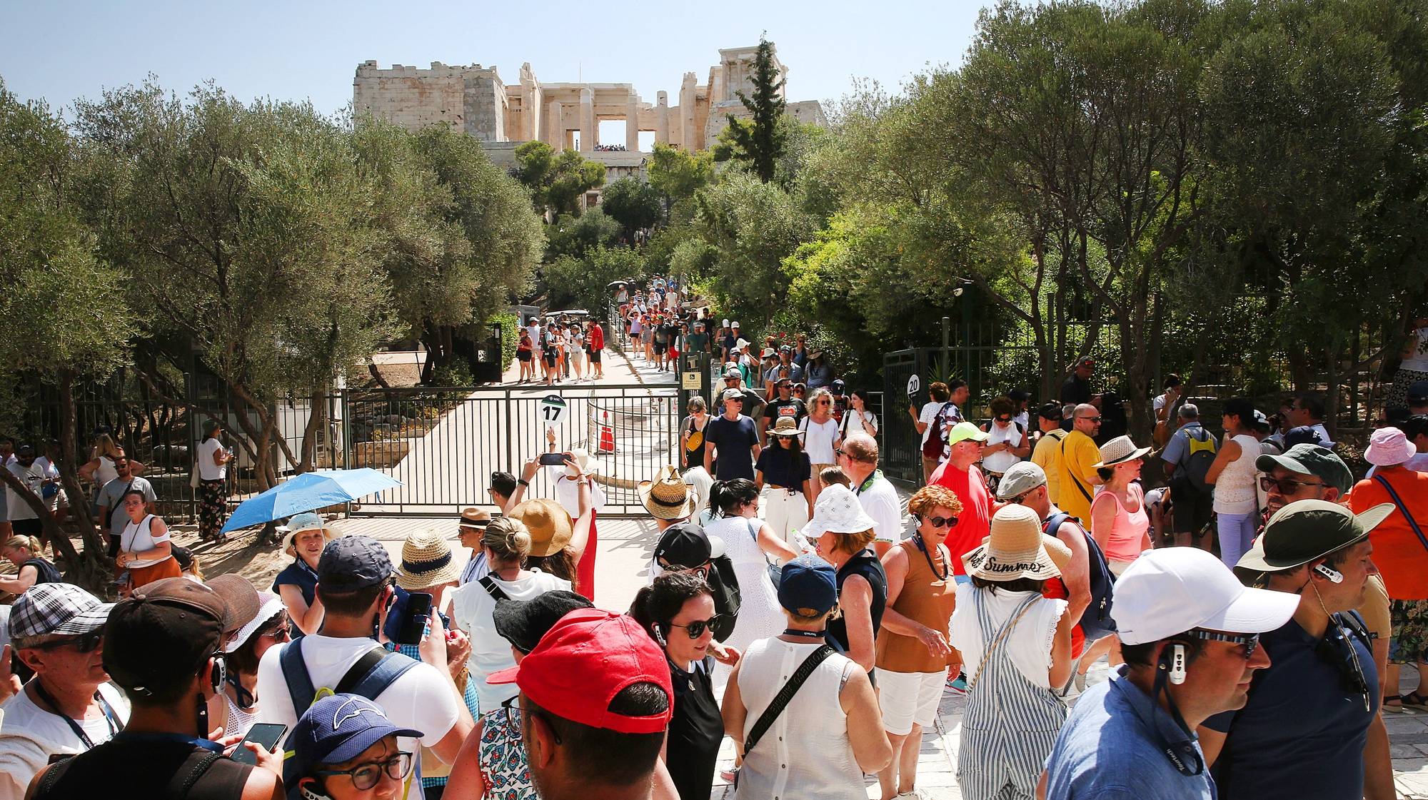 epa10745428 Tourists wait in a long line to visit Acropolis amid high temperatures, in Athens, Greece, 14 July 2023. Archaeological sites in Athens have closed for the public at 12.00 because of the heat. Extremely high temperatures with a potentially serious impact on health are forecast in the Greek capital, Athens, and the cities of Thessaloniki and Larissa over the next few days. Anticyclone Ceber, a high-pressure area coming from the south, will bring extreme heat with temperatures exceeding 40 degrees Celsius to European countries, as well as China and the USA, the European Space Agency (ESA) reported.  EPA/ORESTIS PANAGIOTOU