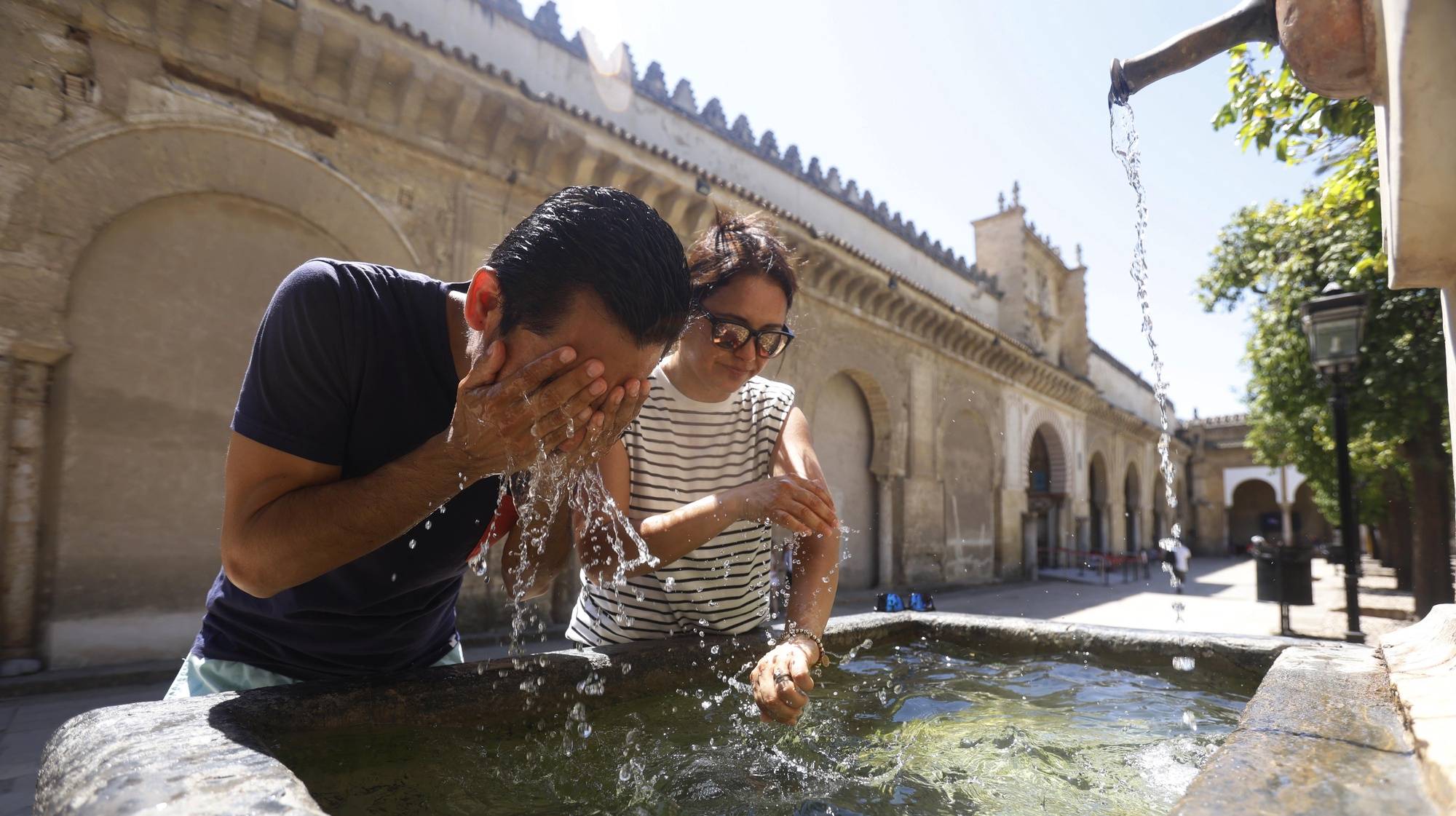 epa11530754 Two tourists refresh themselves in a fountain in Cordoba, southern Spain, 06 August 2023. Spain is fully immersed in the characteristic &#039;canicula&#039; or dog days period, between July 15 and August 15, with temperatures hovering around 40 degrees in many places and dry and sunny weather in practically the entire country.The &#039;canicula&#039; is a very hot period of the year, with temperatures hovering in Spain around 40 degrees in many places.  EPA/SALAS