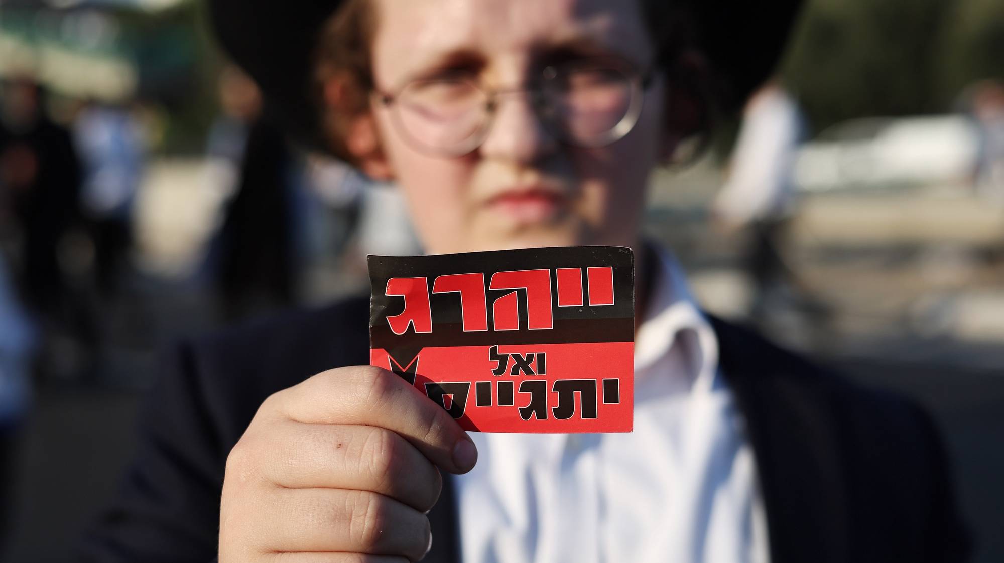 epa11441736 A sign reading &#039;We will not enlist&#039; as Ultra-Orthodox Jews are detained by police as they block highway 4 in Bnei Brak, near Tel Aviv, Israel, 27 June 2024. The protest was against the recruitment of Ultra-Orthodox Jews into the army following a ruling by the Israeli Supreme Court that ultra-Orthodox Jews must also be conscripted into military service.  EPA/ATEF SAFADI