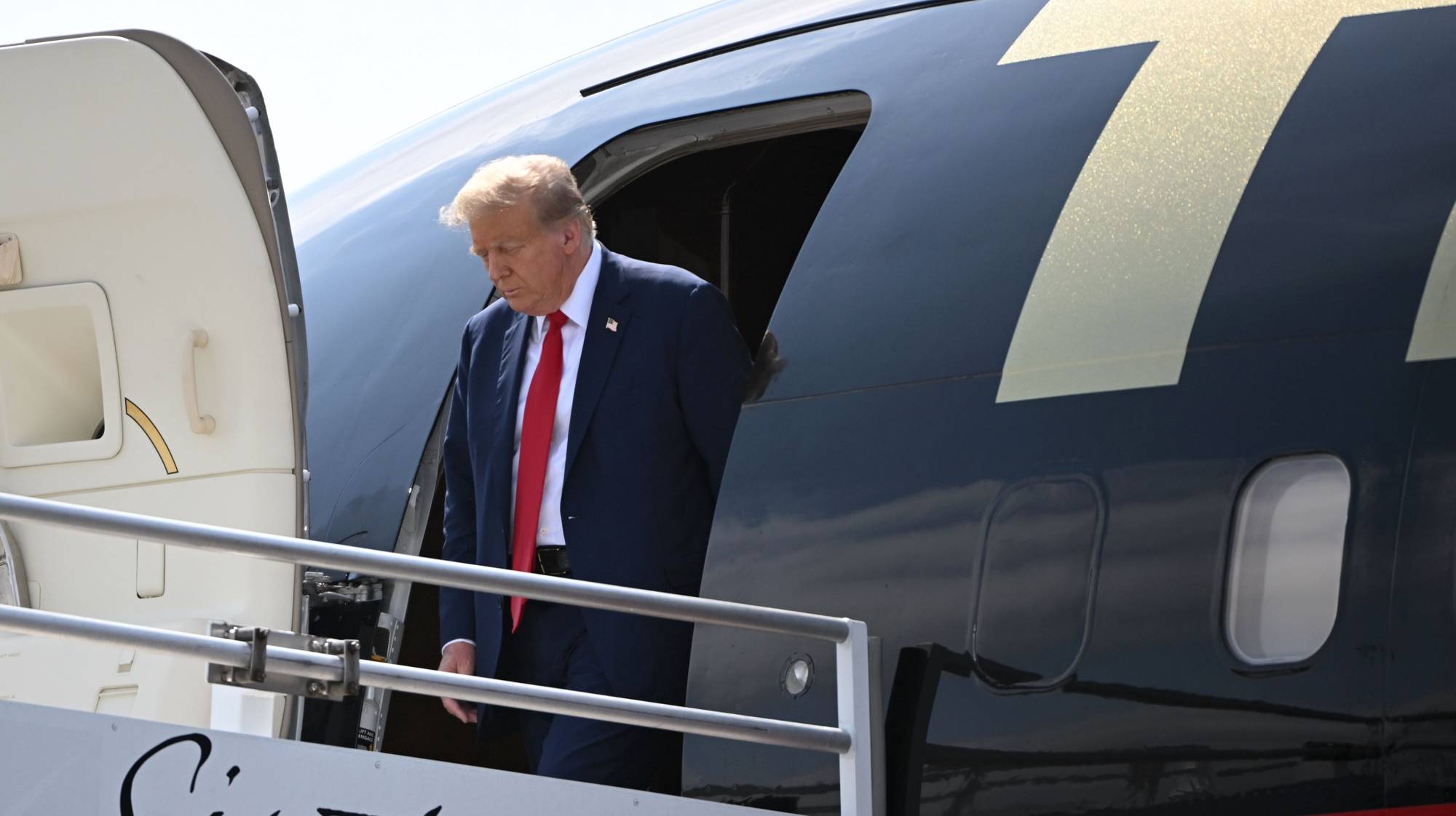 epa11270700 Former president Donald J. Trump walks off his plane at Hartsfield-Jackson Atlanta International Airport, in Atlanta, Georgia, USA, 10 April 2024, as he arrives for a political fundraiser.  EPA/EDWARD M. PIO RODA