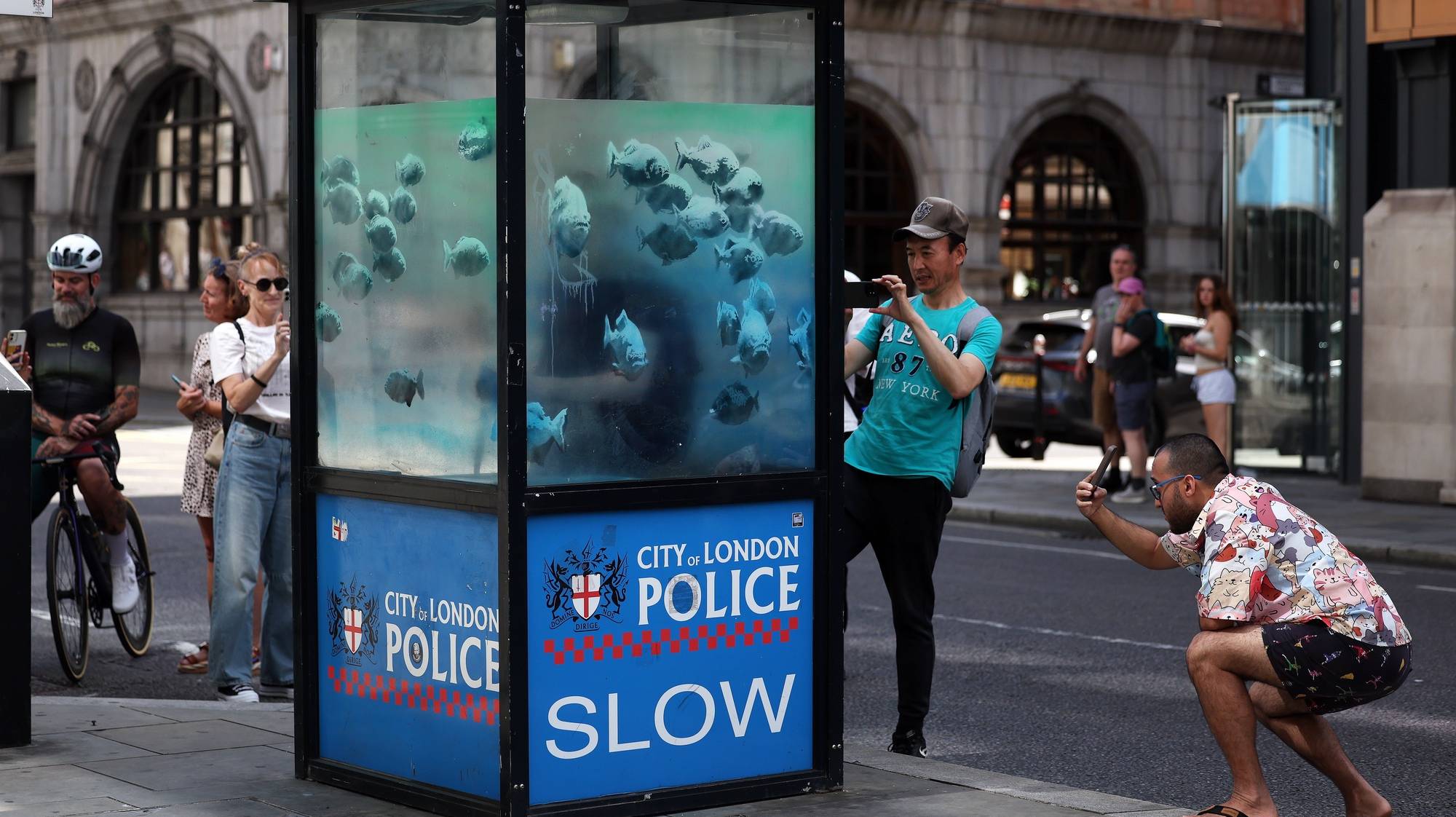 epa11545404 People gather to look at an artwork by Britain-based street artist Banksy on an old police sentry box in the City of London in London, Britain, 11 August 2024. It is the seventh animal artwork claimed by the artist in the past week. Banksy has claimed one art piece a day for seven days, posting a photo at 1pm local time on social media every day.  EPA/ANDY RAIN