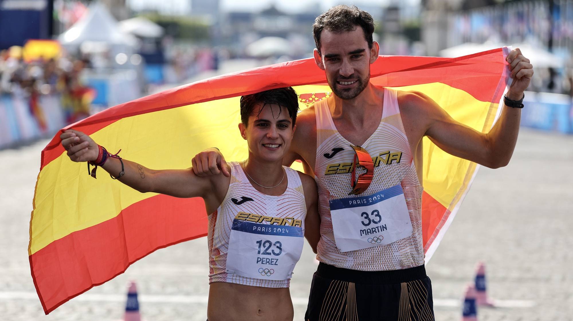 epa11532592 Gold medalists Maria Perez (L) and Alvaro Martin of Spain pose with their national flag after winning the Marathon Race Walk Relay Mixed event of the Athletics competitions in the Paris 2024 Olympic Games, in Paris, France, 07 August 2024.  EPA/MIGUEL GUTIERREZ