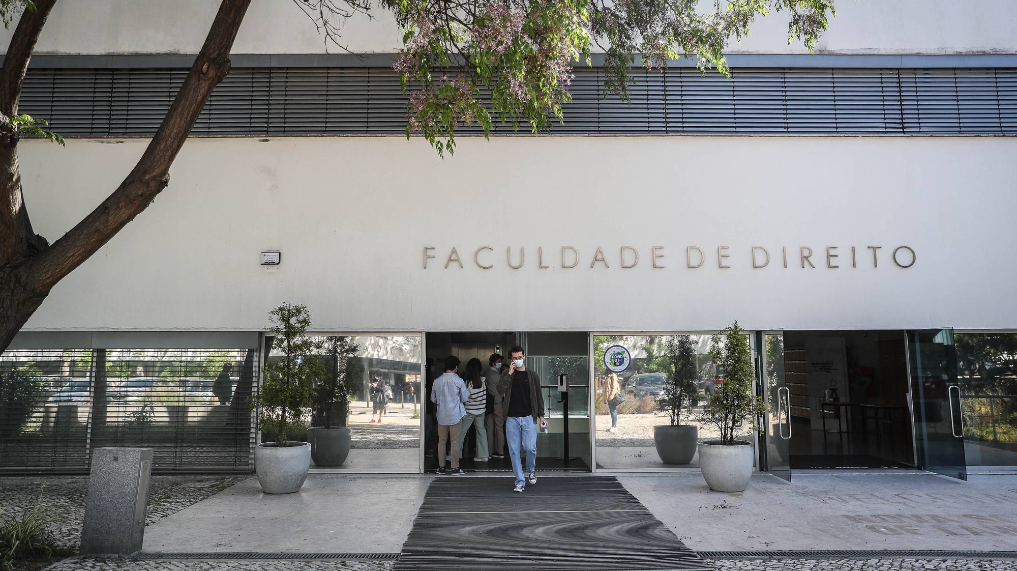 Alunos na entrada da Faculdade de Direito da Universidade de Lisboa, no dia em que se assinala o regresso às aulas no âmbito das novas medidas de desconfinamento relacionadas com a pandemia da covid-19, no Campus de Campolide, em Lisboa, 19 de abril de 2021. Portugal inicia hoje a terceira fase do desconfinamento com a reabertura de mais escolas, lojas, restaurantes e cafés, um levantamento de restrições que não é acompanhado nos 10 concelhos onde a incidência da covid-19 é maior. MÁRIO CRUZ/LUSA