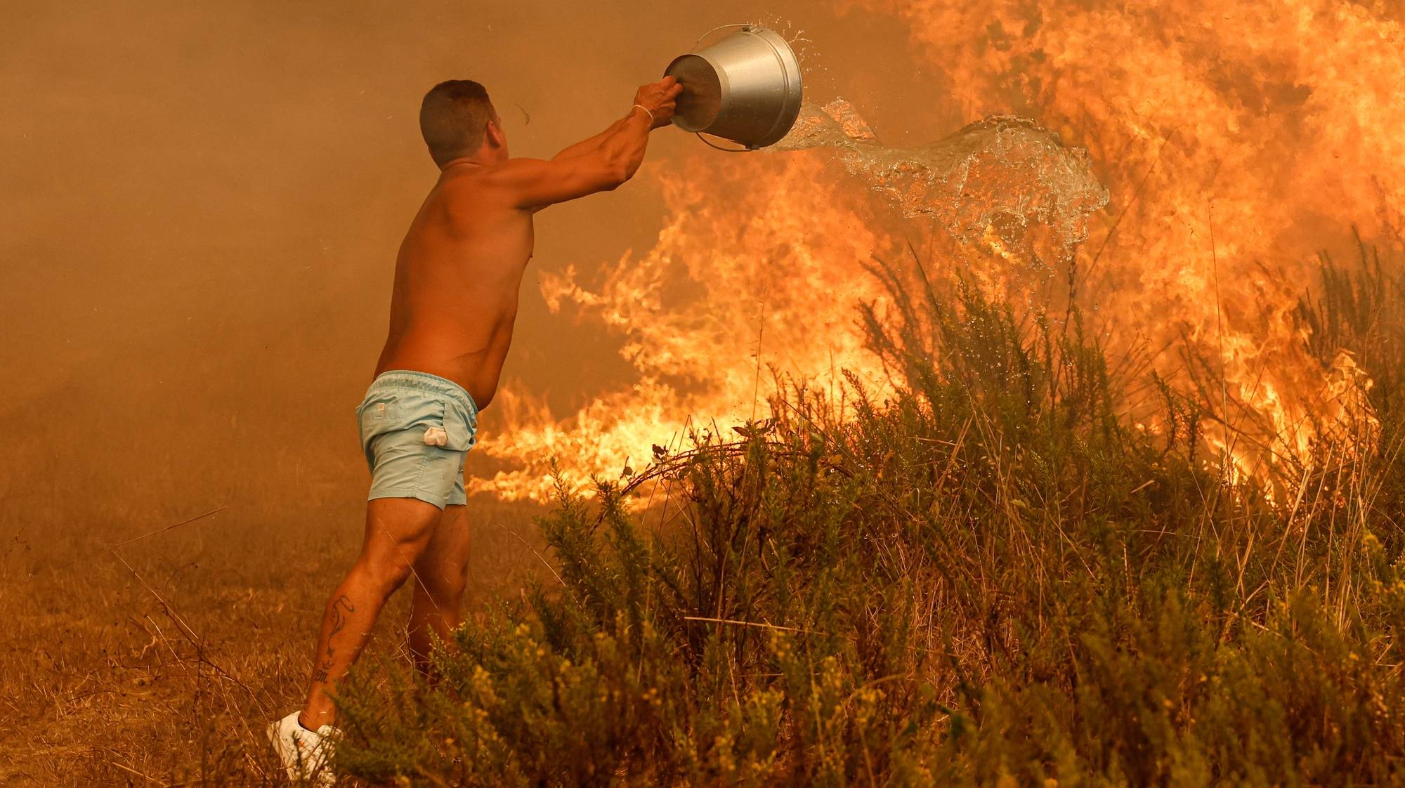 Populares combatem o fogo, na zona de Aljezur, concelho de Odemira. Estão no combate às chamas 633 operacionais, apoiados por 206 viaturas terrestres e 10 meios aéreos. O incêndio, que deflagrou na zona de Baiona, na freguesia de São Teotónio, a meio da tarde de sábado, já obrigou a evacuar quatro locais no concelho de Odemira (Vale dos Alhos, Vale de Água, Choça dos Vales e Relva Grande) e uma unidade de turismo rural, num total de mais de 100 pessoas retiradas, 07 de agosto de 2023. LUÍS FORRA/LUSA