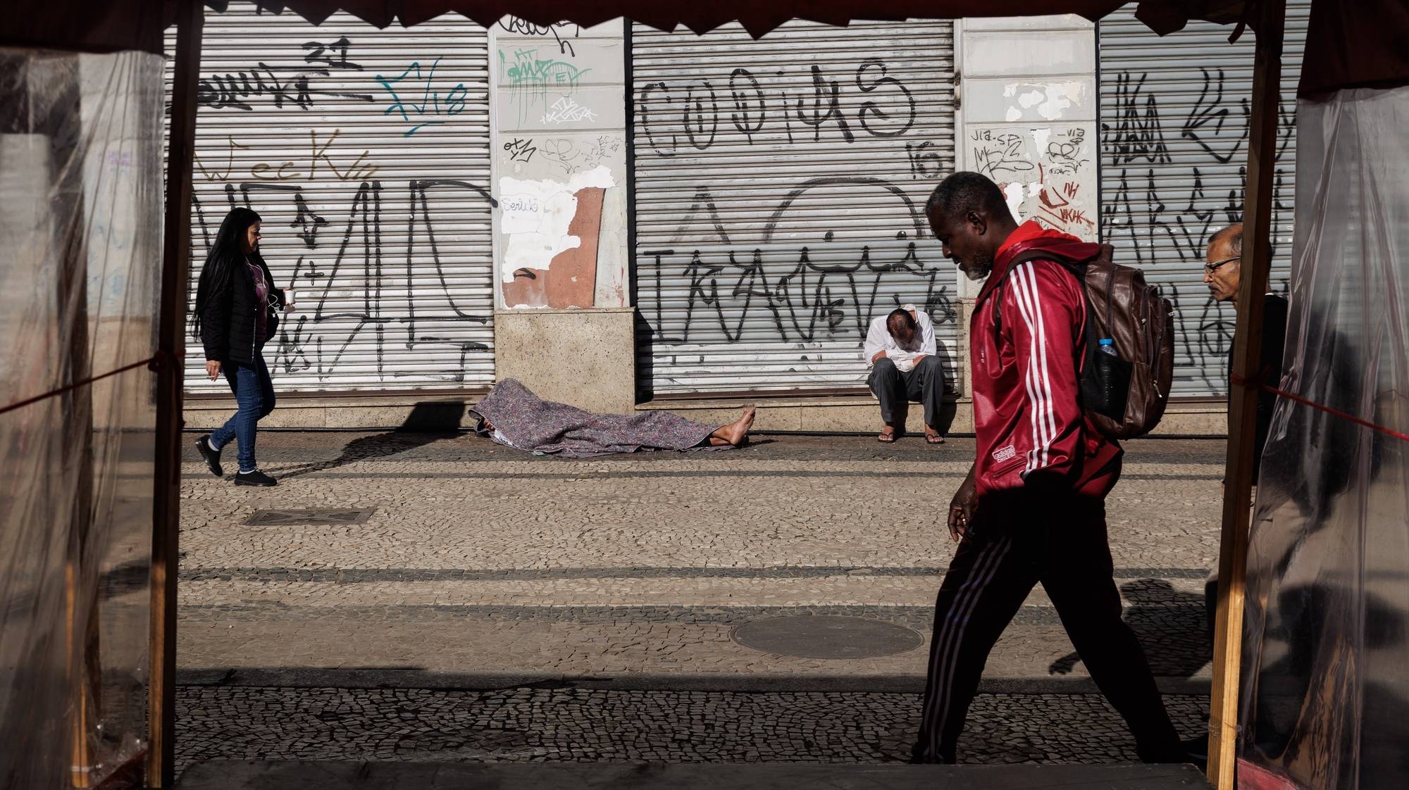 epa11494171 Pedestrians walk by homeless people sleeping in the city center in Sao Paulo, Brazil, 24 July 2024. According to a report released on 24 July 2024 by five United Nations agencies, hunger levels remained high in 2023 for the third consecutive year, with approximately 733 million people worldwide suffering from chronic undernourishment.  EPA/Isaac Fontana