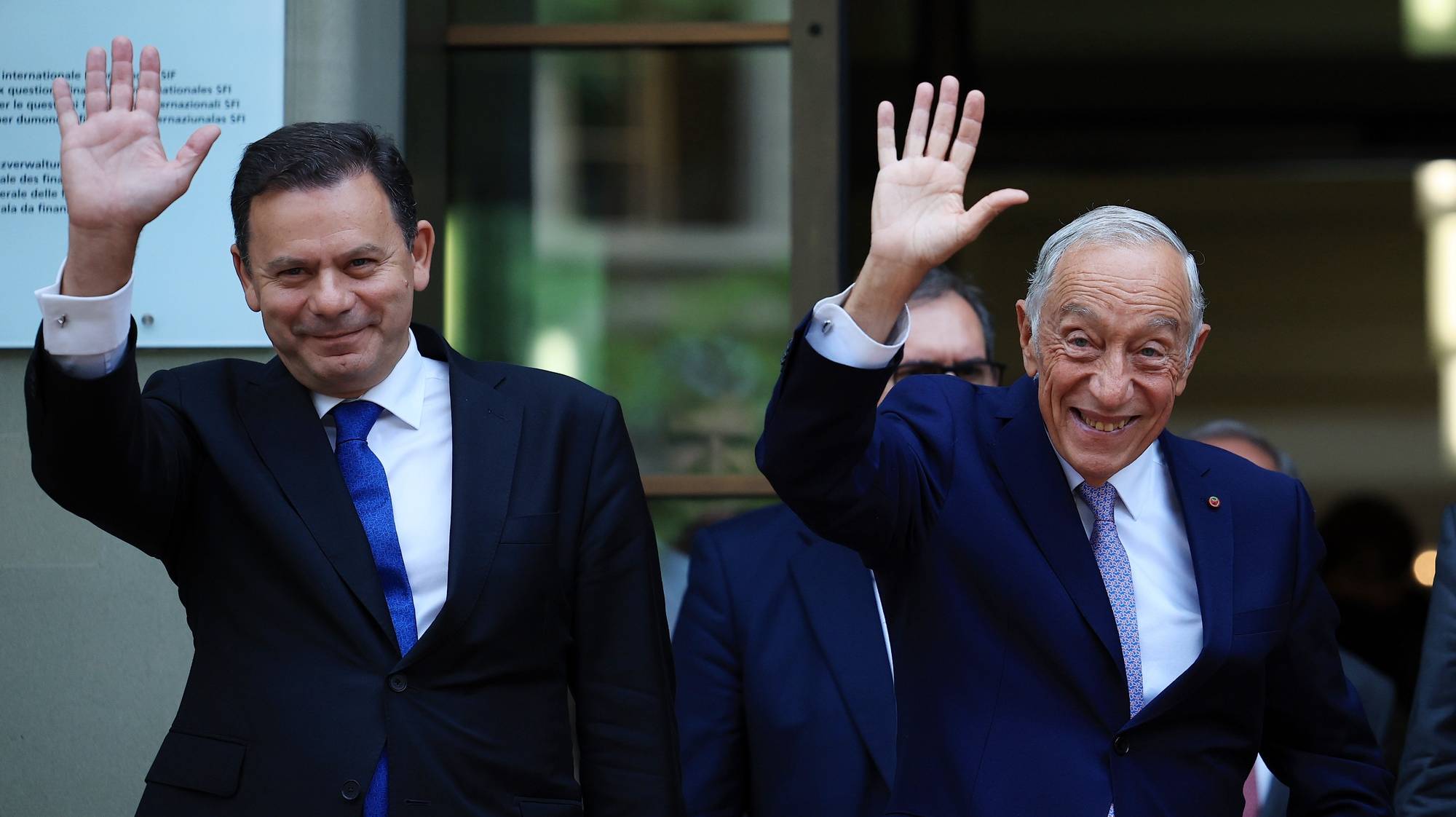 O Presidente da República, Marcelo Rebelo de Sousa (D), e o primeiro-ministro, Luís Montenegro (E), acenam no final de um encontro com a Presidente da Confederação Suíça, Viola Amherd (ausente da fotografia), em Berna, Suíça, 12 de junho de 2024. O Presidente da República e o primeiro-ministro portugueses terminam hoje a deslocação oficial à Suíça por ocasião das celebrações do Dia de Portugal, de Camões e das Comunidades Portuguesas. ESTELA SILVA/LUSA