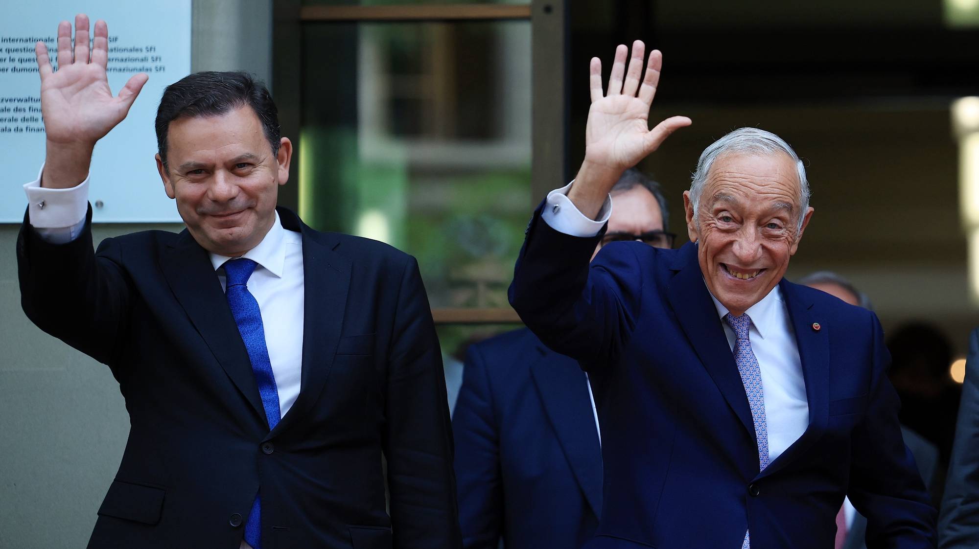 O Presidente da República, Marcelo Rebelo de Sousa (D), e o primeiro-ministro, Luís Montenegro (E), acenam no final de um encontro com a Presidente da Confederação Suíça, Viola Amherd (ausente da fotografia), em Berna, Suíça, 12 de junho de 2024. O Presidente da República e o primeiro-ministro portugueses terminam hoje a deslocação oficial à Suíça por ocasião das celebrações do Dia de Portugal, de Camões e das Comunidades Portuguesas. ESTELA SILVA/LUSA