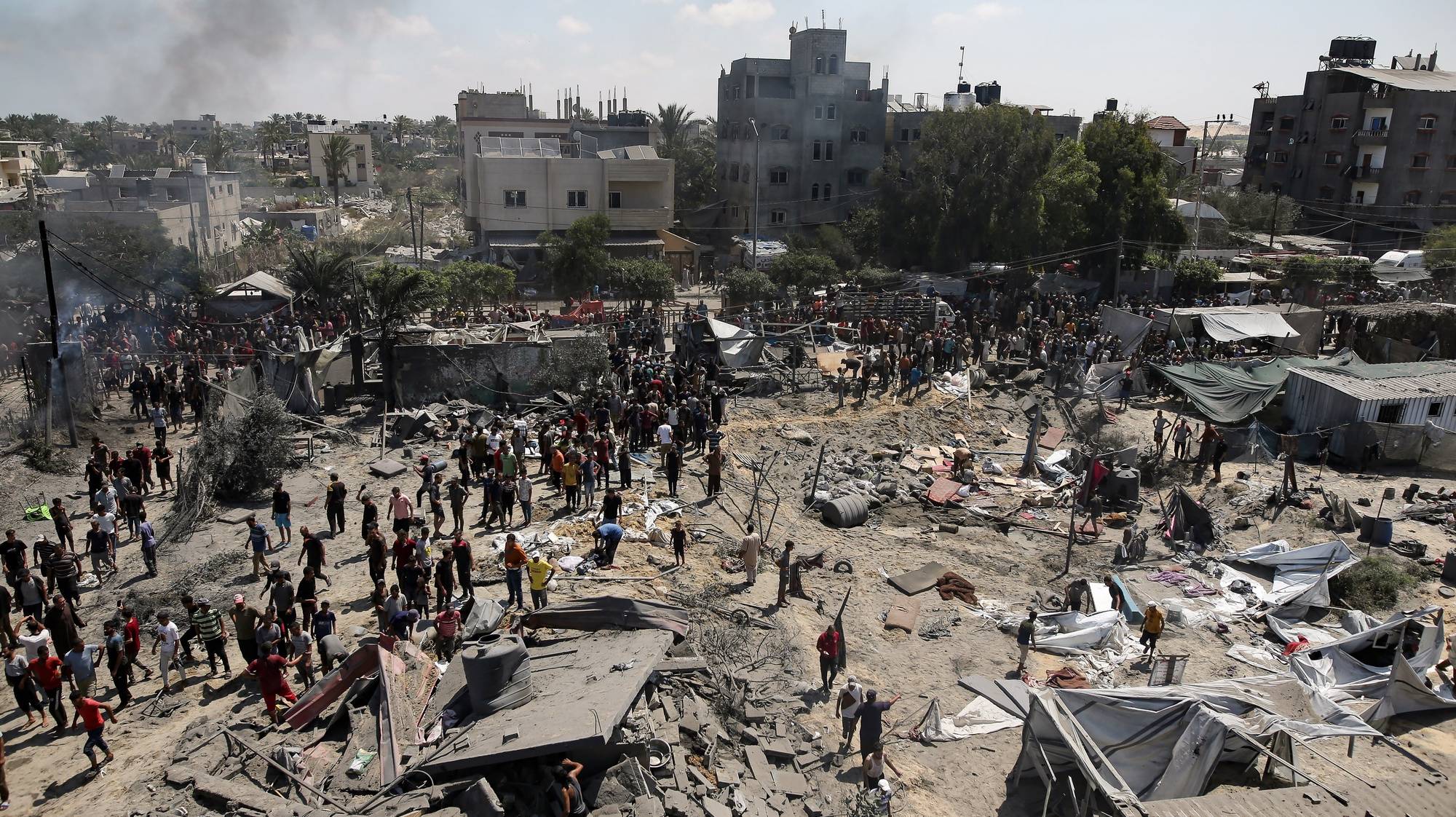 epa11475533 Palestinians inspect the scene after an Israeli raid on the tents of displaced people in the Al-Mawasi area of Khan Yunis in the southern Gaza Strip, 13 July 2024. Gaza’s health ministry said at least 71 Palestinians were killed in the Israeli attack in Khan Younis, 289 others were injured. Israeli military confirmed it targeted Hamas military chief, Mohammed Deif, in Saturday’s attack in Gaza.  EPA/HAITHAM IMAD