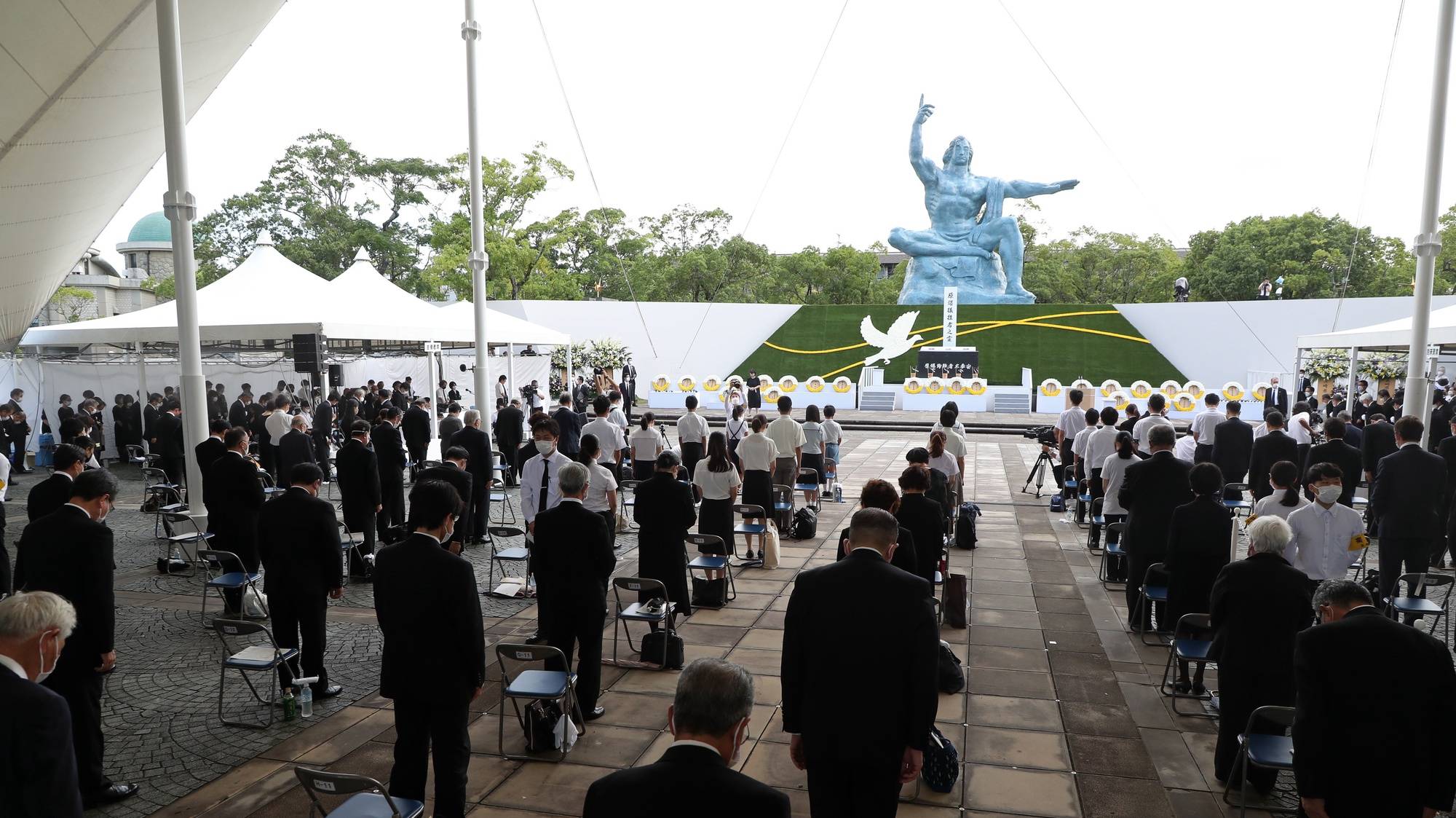 epa09406890 People observe a moment of silence during a ceremony at Peace Park in Nagasaki, southern Japan, 09 August 2021. Nagasaki marks the 76th anniversary of the atomic bombing on 09 August 1945, as related events are either canceled or scaled down this year to avoid the spreading of the coronavirus and COVID-19 disease pandemic.  EPA/JIJI PRESS JAPAN OUT EDITORIAL USE ONLY/  NO ARCHIVES