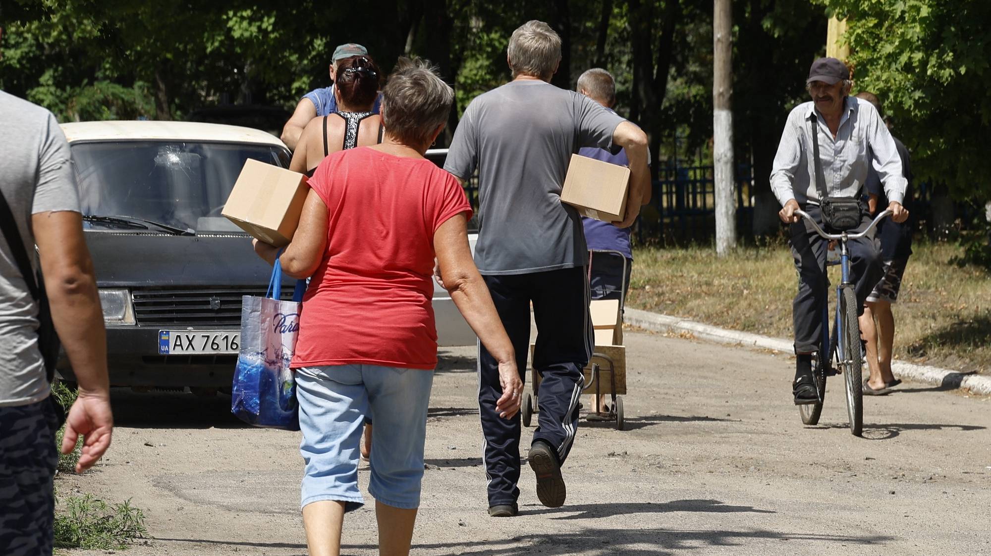 epa11537360 Locals receive hygienic sets delivered by volunteers and by the Relief Service Ukraine of Order of Malta as humanitarian aid in Monachynivka village near Kupiansk in the Kharkiv area, Ukraine, 08 August 2024. All shops in villages close to the frontline are closed and locals have to rely on relief services to get essential commodities following a cross-border offensive by Russian forces on the Kharkiv region since May 2024. Russian troops entered Ukrainian territory on 24 February 2022, starting a conflict that has provoked destruction and a humanitarian crisis.  EPA/SERGEY KOZLOV