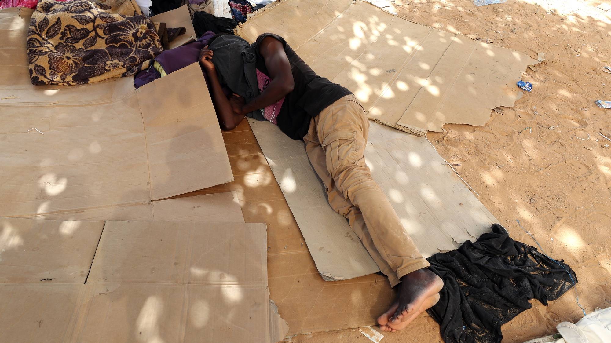 epa10760606 A Sub-Saharan African migrant sleeps in a public garden in Sfax, in the south of Tunis, Tunisia, 21 July 2023. According to the Red Crescent, in Sfax, the second most important city in Tunisia, almost 1.500 Sub-Saharan African migrants, including children, try to find the shadow and water to survive in a public garden for two weeks. Most of them entered Tunisia in an unauthorized way and come from Sudan, Nigeria, Liberia, Mali, Burkina Faso and Guinea. According to the nongovernmental group Tunisian Forum for Economic and Social Rights (FTDES), between January and May 2023, Tunisian authorities arrested over 3,500 migrants for &#039;irregular stay&#039; and intercepted over 23,000 people attempting irregular departures from Tunisia.  EPA/MOHAMED MESSARA