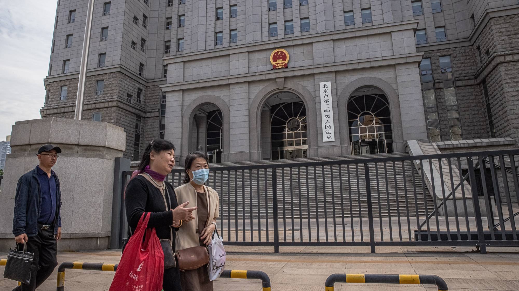 epa09230618 People walk past the Intermediate People&#039;s Court where Australian writer Yang Hengjun is expected to face trial, in Beijing, China, 27 May 2021. Australian writer Yang Hengjun, who was arrested in early 2019, is expected to face court in Beijing on espionage charges on 27 May 2021.  EPA/ROMAN PILIPEY