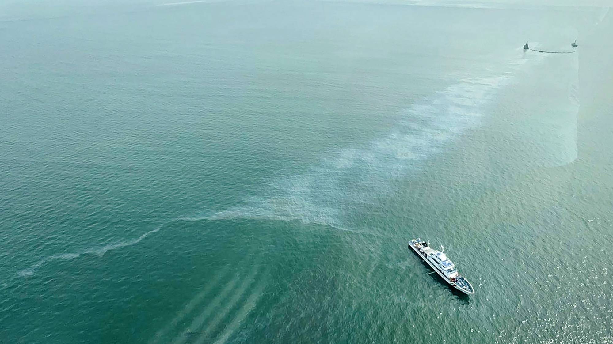 epa11498539 A handout photo made available by the Presidential Communications Office (PCO) taken through the window of a helicopter during an aerial inspection flight attended by President Ferdinand Marcos (unseen) shows Coastguard ships with an oil spill boom trying to contain an oil spill during salvage operations at the position of a sunken oil tanker off the Manila Bay, Philippines, 27 July 2024. The Philippines raced to prevent an environmental catastrophe in the Manila Bay, as the Coastguard reported an oil slick that appeared where the oil tanker &#039;MT Terra Nova&#039; carrying 1.4 million liters of industrial fuel oil sank 25 July. Local authorities imposed a temporary fishing ban in Limay town, impacting thousands of fishermen’s livelihoods.  EPA/PRESIDENTIAL COMMUNICATIONS OFFICE HANDOUT HANDOUT EDITORIAL USE ONLY/NO SALES