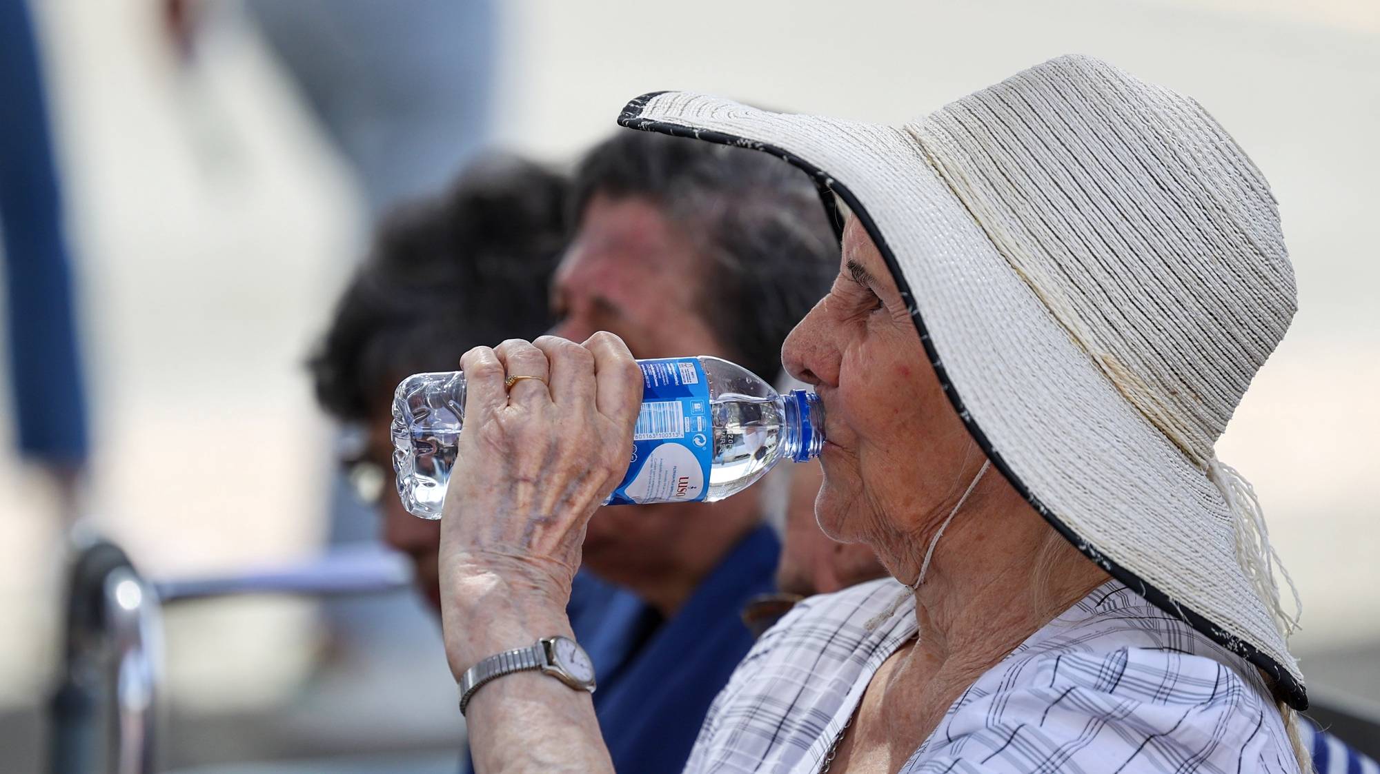 Uma visitante da 39.ª edição da Ovibeja hidrata-se, com temperaturas esta tarde a rondar os 35 graus, devido a uma vaga de calor provocada por “uma massa de ar quente com origem no norte de África e transportada na circulação de um anticiclone localizado junto à Península Ibérica”, em Beja, 27 de abril de 2023. NUNO VEIGA/LUSA