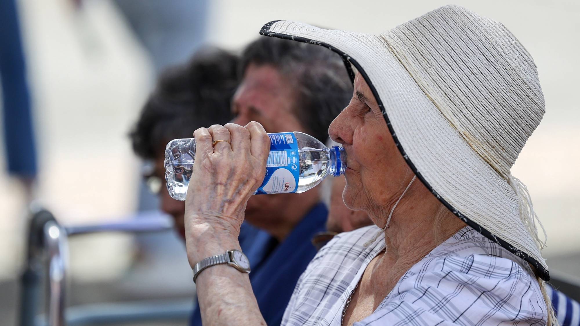 Uma visitante da 39.ª edição da Ovibeja hidrata-se, com temperaturas esta tarde a rondar os 35 graus, devido a uma vaga de calor provocada por “uma massa de ar quente com origem no norte de África e transportada na circulação de um anticiclone localizado junto à Península Ibérica”, em Beja, 27 de abril de 2023. NUNO VEIGA/LUSA