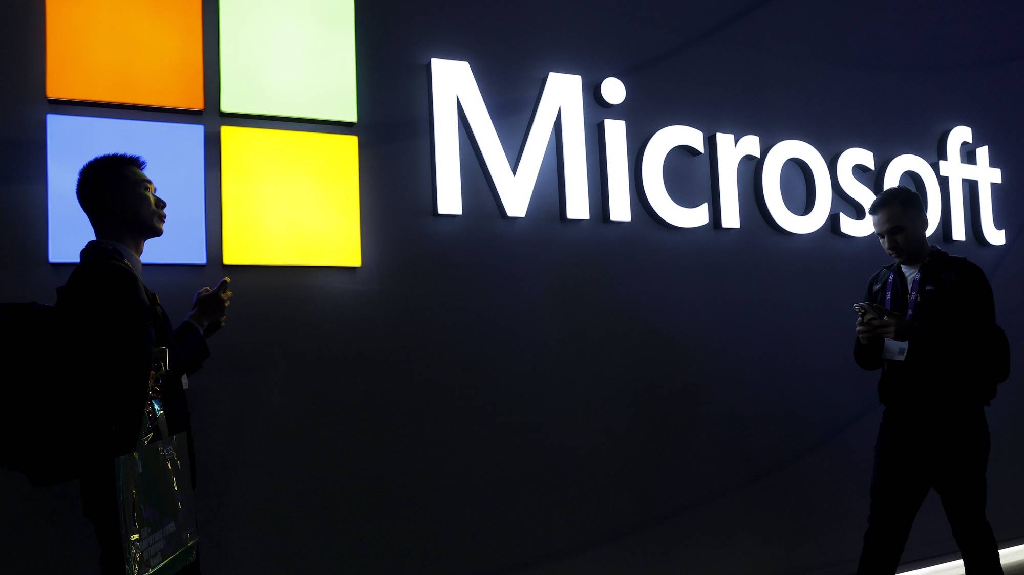 epa11184330 Two visitors walk in front of Microsoft stand during the second day of the MWC (Mobile World Congress) 2024 in Barcelona, Catalonia, north-eastern Spain, 27 February 2024. MWC Barcelona, the largest event for the connectivity ecosystem, will run from 26 to 29 February.  EPA/TONI ALBIR