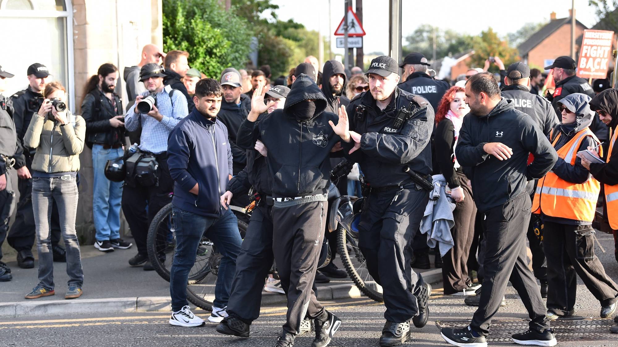 epaselect epa11534599 Police remove a protester who refused to remove their face mask outside the Merseyside Refugee Centre in Liverpool, Britain, 07 August 2024. Further far-right protests are expected throughout Britain on the 07 August 2024. Violent demonstrations have been held by members of far-right groups across Britain following a fatal stabbing attack in Southport, in which three children were killed and eight more seriously injured, along with two adults.  EPA/PETER POWELL