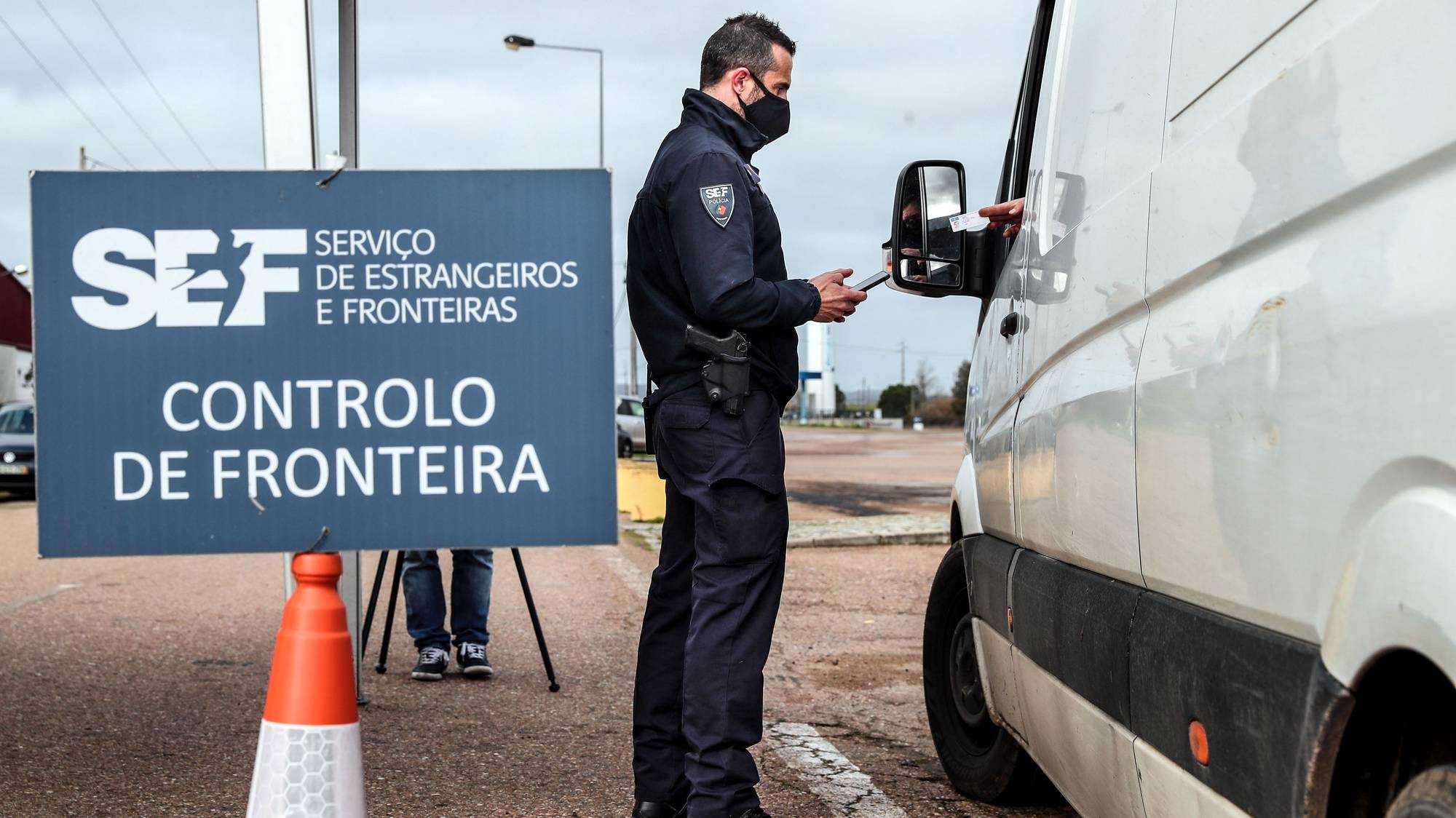 Um agente do Serviço de Estrangeiros e Fronteiras (SEF) verifica a identificação de um automobilista durante uma operação de controlo na entrada em Portugal pela fronteira do Caia (Elvas), 1 de fevereiro de 2021. As fronteiras foram repostas desde as 00:00 de domingo, dia 31 de janeiro, no âmbito das medidas para conter a propagação da covid-19 no território português. NUNO VEIGA/LUSA