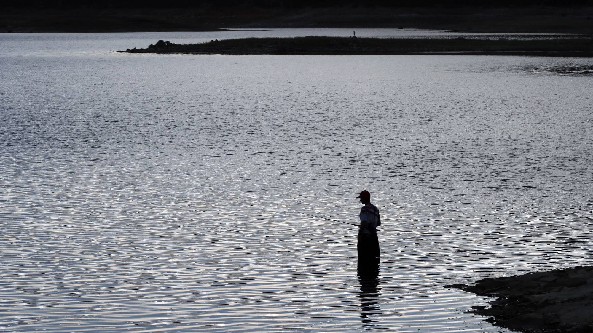 Um pescador no lago de alqueva, na praia fluvial de Monsaraz. Reguengos de Monsaraz, 10 de outubro de 2022. NUNO VEIGA/LUSA