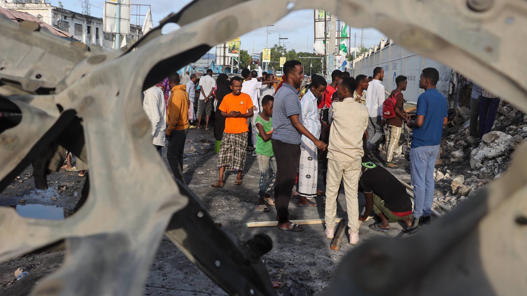epa11479477 People look at the damage at the site of a bomb attack in Mogadishu, Somalia, 15 July, 2024. Nine people were killed and more than 20 wounded late 14 July when a car bomb struck a cafe packed with football fans watching the final of the Euro 2024, Mohamed Yusuf, an official from the national security agency confirmed on 15 July.  EPA/SAID YUSUF WARSAME