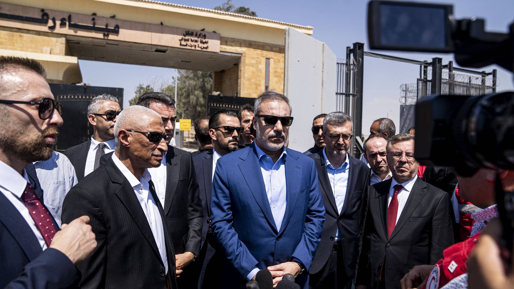 epa11524990 Turkish Foreign Minister Hakan Fidan (C) speaks during his visit to Rafah border crossing with the Gaza Strip, in Rafah, Egypt, 04 August 2024. Fidan is on a two-day official visit to Egypt during which he will have talks on bilateral relations as well as current international and regional developments, a Turkish foreign ministry statement reads.  EPA/MOHAMED ARAFAT