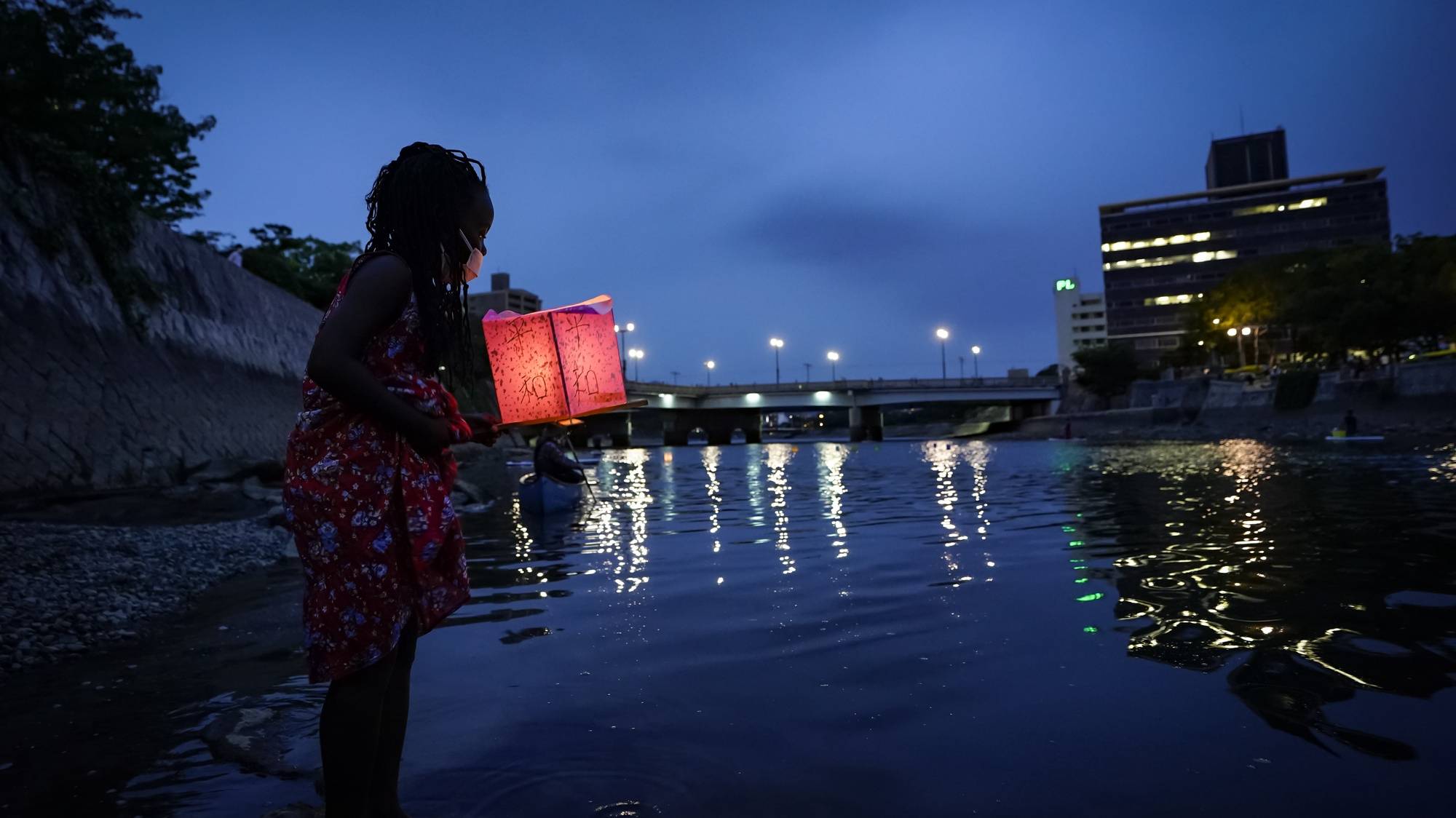 epa08587259 Seven-year-old Kenyan girl Joyce Makokha stands in the water as she placs a lantern on the water of Motoyasu River near the Peace Memorial Park in Hiroshima, western Japan, 06 August 2020. Only a handful of representatives released lanterns on the water after the annual floating lantern event which attracts thousands of people has been canceled this year to avoid the spreading of the coronavirus disease (COVID-19) pandemic. On 06 August 2020 Japan marks the 75th anniversary of the bombing of Hiroshima. In 1945 the United States dropped two nuclear bombs over the cities of Hiroshima and Nagasaki on 06 and 09 August respectively, killing more than 200,000 people. This year&#039;s commemoration events were either canceled or scaled down amid the ongoing coronavirus pandemic.  EPA/DAI KUROKAWA