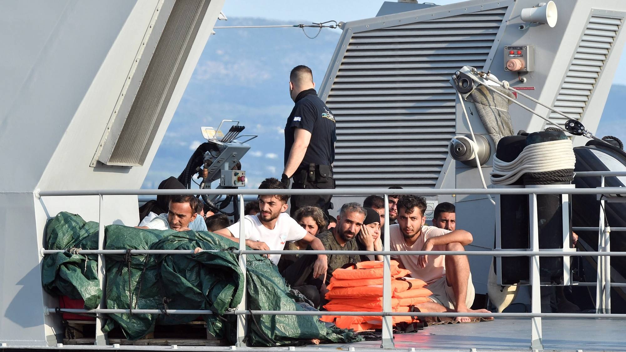 epa10704615 Migrants onboard of a Coast Guard vessel arrive to port in Kalamata, Peloponnese, Greece, 21 June 2023. The vessel transported 63 migrants, who were found on a sailboat 27 nautical miles southwest of Tainaros, Greece. The rescued people, who say they are mainly citizens of Iraq, Iran, Syria and Morocco, have been transferred to the warehouses where they will remain until the migration proceedings are completed.  EPA/NIKITAS KOTSIARIS