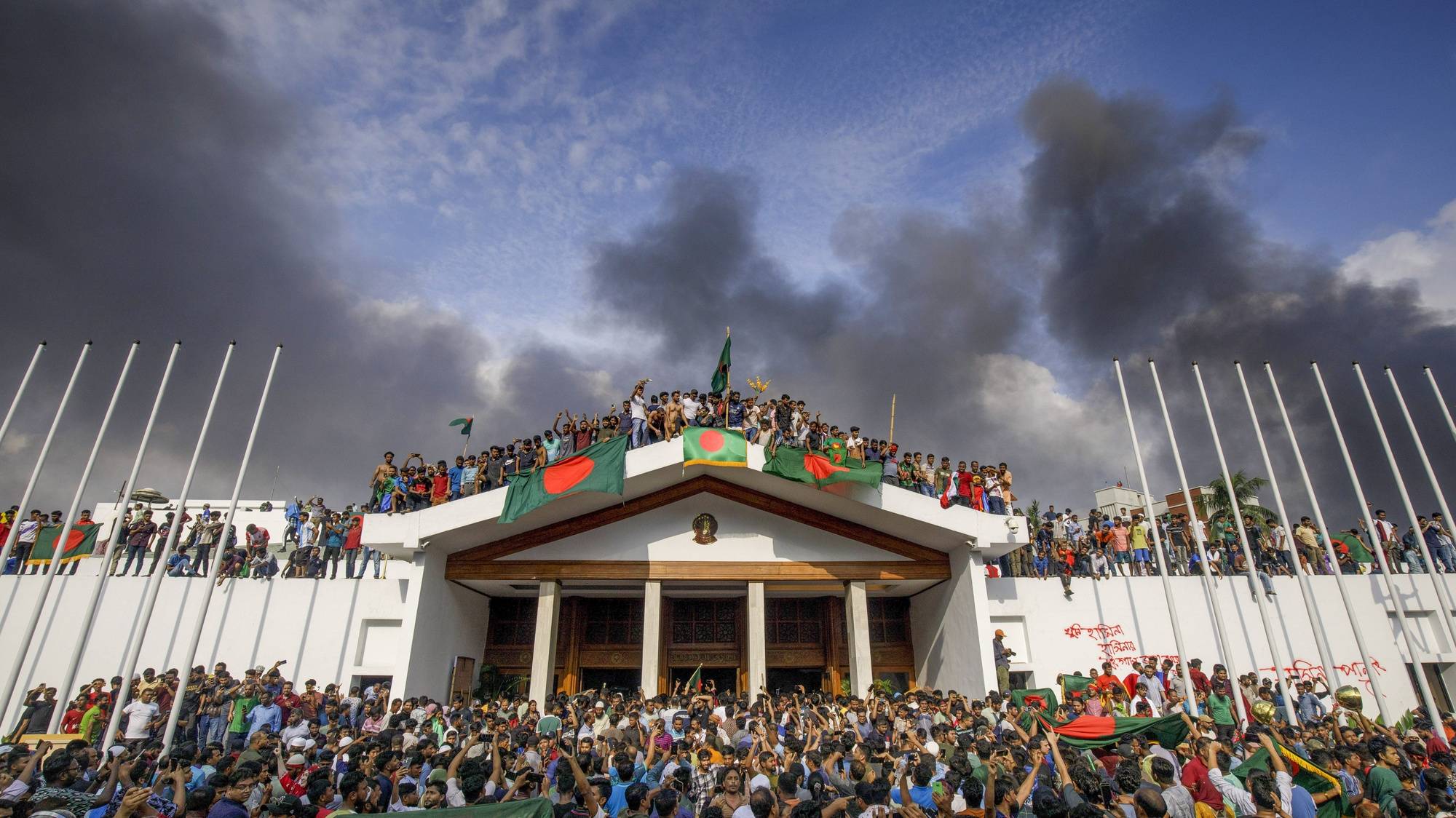 epaselect epa11528484 People gather around the residence of Bangladeshi prime minister in Dhaka, Bangladesh, 05 August 2024. In an address to the nation, Chief of Army Staff General Waker-Uz-Zaman announced that Prime Minister Sheikh Hasina has resigned after weeks of unrest and an interim government will be formed to run the country. Dhaka authorities have imposed a new curfew starting 06:00 p.m. local time on 04 August. As casualties mounted and law enforcement struggled to contain the unrest, the Bangladeshi government on 20 July 2024 had imposed an initial nationwide curfew and deployed military forces after violence broke out in Dhaka and other regions following student-led protests demanding reforms to the government&#039;s job quota system.  EPA/STR