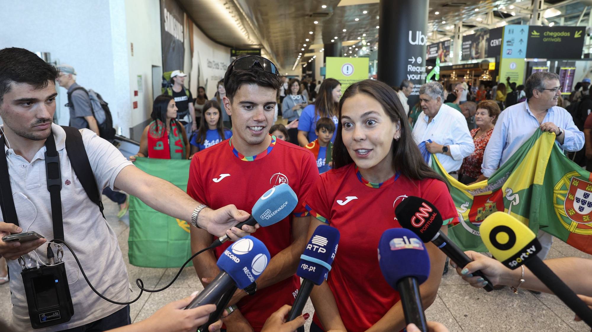 A triatleta Melanie Santos e o triatleta Ricardo Batista, falam aos jornalistas à chegada ao aeroporto Humberto Delgado, após a sua participação nos Jogos Olímpicos Paris2024, tendo a equipa portuguesa concluído em 5º lugar a prova de triatlo, Lisboa, 07 de agosto de 2024. MIGUEL A. LOPES/LUSA