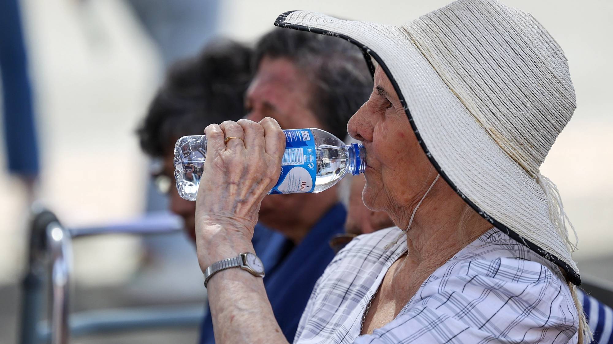 Uma visitante da 39.ª edição da Ovibeja hidrata-se, com temperaturas esta tarde a rondar os 35 graus, devido a uma vaga de calor provocada por “uma massa de ar quente com origem no norte de África e transportada na circulação de um anticiclone localizado junto à Península Ibérica”, em Beja, 27 de abril de 2023. NUNO VEIGA/LUSA