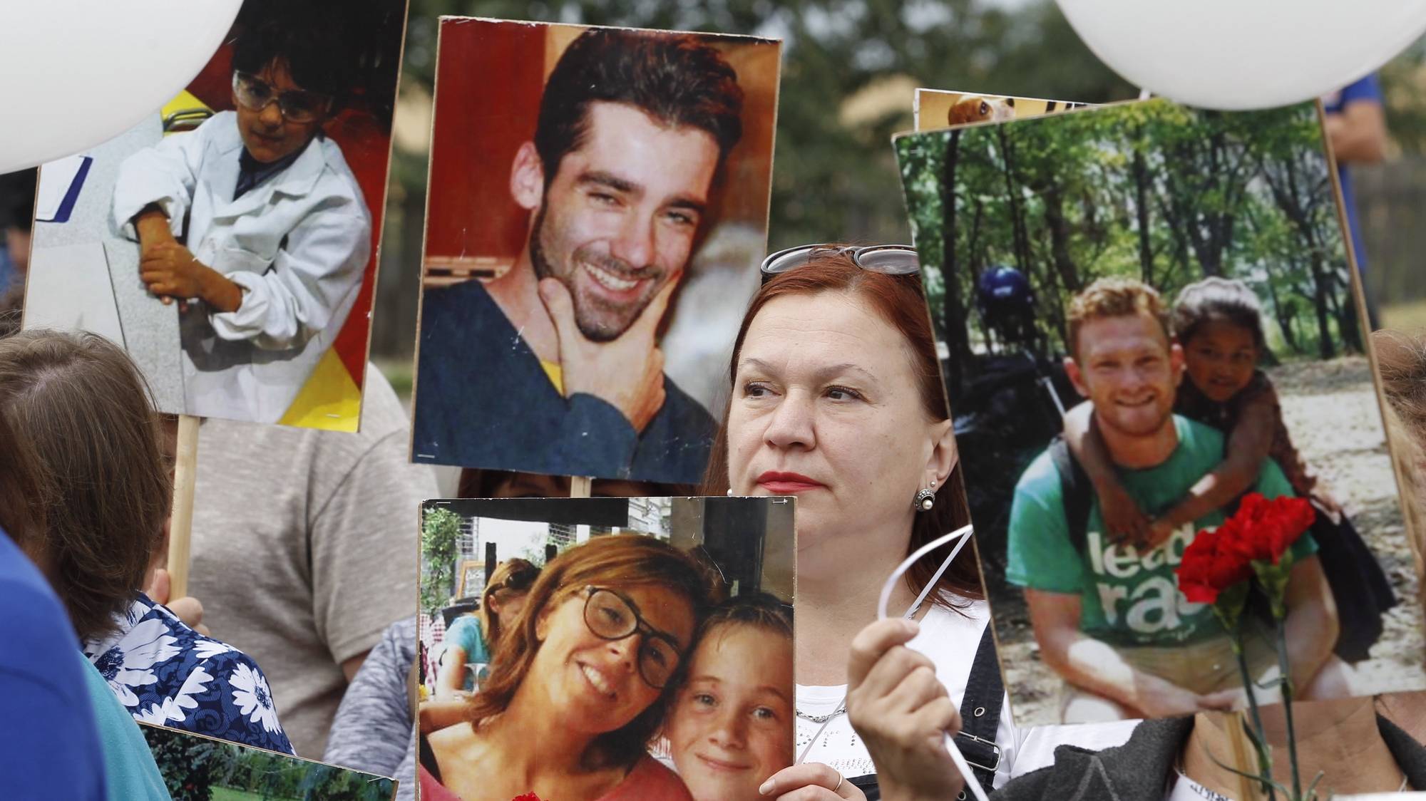 epa08552030 Local people hold portraits of lost passengers during a mourning ceremony at the crash site of the MH17 plane, on the sixth anniversary of the disaster, near the pro-Russian militant&#039;s controlled village of Grabovo, around 100 kilometers east from Donetsk, Ukraine, 17 July 2020. Malaysia Airlines Flight MH-17 was shot down on 17 July 2014 while flying over eastern Ukraine, killing all 283 passengers and 15 crew on board.  EPA/DAVE MUSTAINE