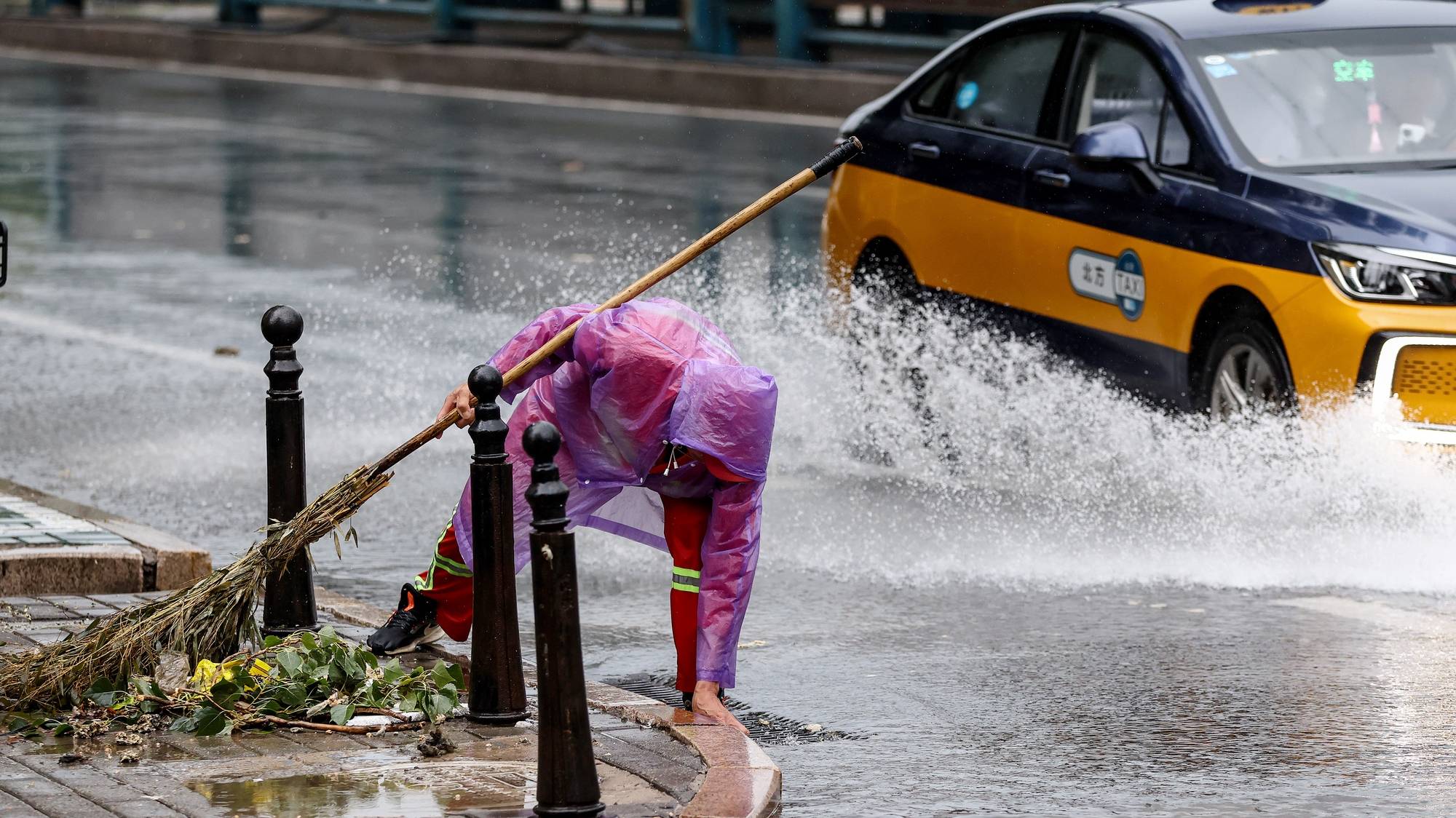 epa11508207 A cleaner works on a street during heavy rain in Beijing, China, 30 July 2024. The Central Meteorological Observatory continued to issue an orange rainstorm alert on 30 July 2024. It is expected that there will be heavy rainstorm in parts of central and northern Hebei, northeastern Shanxi, southeastern Inner Mongolia, Beijing, Tianjin and western Liaoning, from 30 to 31 July.  EPA/WU HAO