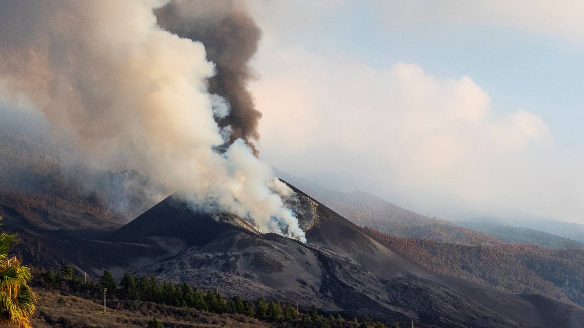 epa09598259 Smoke rises from the Cumbre Vieja volcano seen from El Paso, La Palma, Canary Islands, Spain, 22 November 2021. The Cumbre Vieja volcano erupted on 19 September and has spewn out smoke, ashes and lava since then.  EPA/Miguel Calero