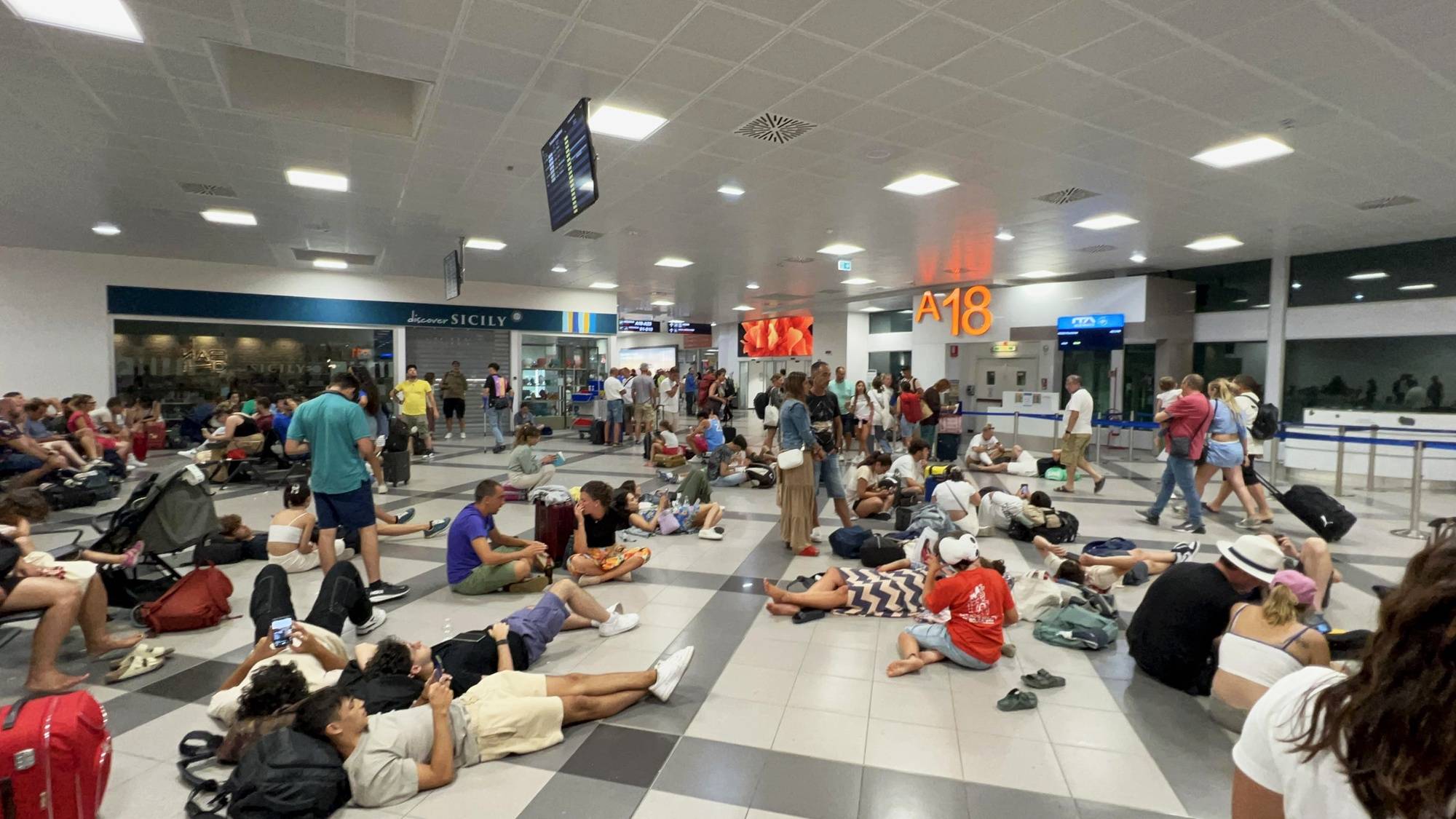 epa11488441 Passengers lay on the floor as they wait to board at Palermo airport, Sicily island, Italy, 19 July 2024. Operations at various airports and airlines have reported being impacted by a global tech outage in systems running Microsoft Windows linked to a faulty CrowdStrike cyber-security software update. According to CrowdStrikeâ€™s CEO, the issue has been identified, isolated and a fix has been deployed. Airlines in Europe, Asia, the Middle East and North America have reportedly been impacted and some businesses have also been affected.  EPA/IGOR PETYX