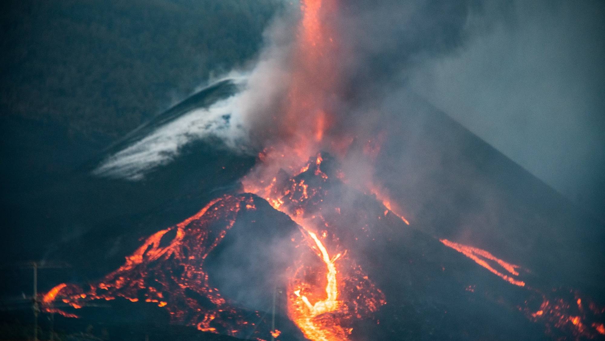 epa09545960 View of the erupting Cumbre Vieja volcano and the stream of lava from the municipality of El Paso, on the island of La Palma, the Canaries, Spain, 25 October 2021. The Cumbre Vieja volcano is erupting since 19 September 2021.  EPA/MIGUEL CALERO