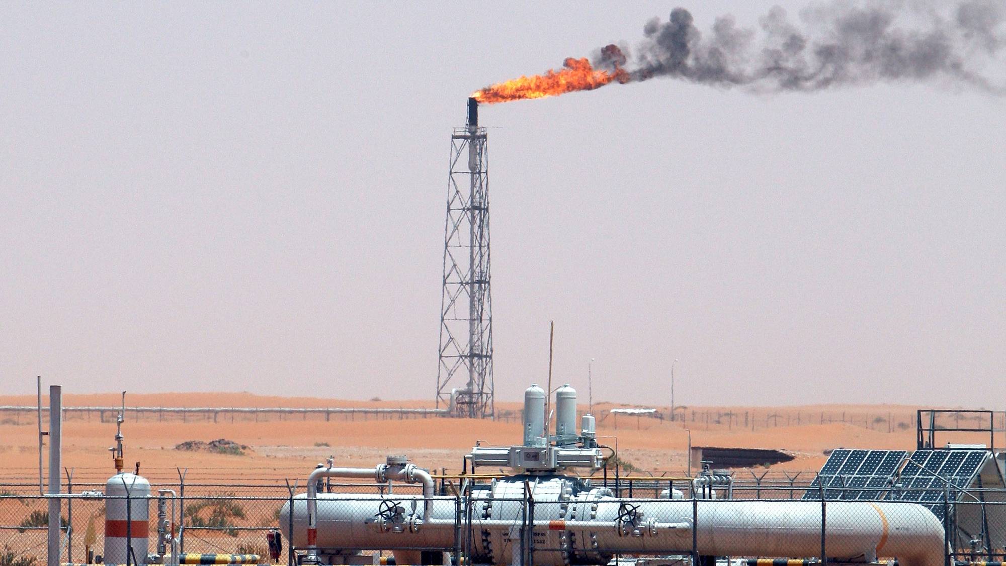 epa09087338 (FILE) - A gas flame behind pipelines in the desert at Khurais oil field, about 160 km from Riyadh, Kingdom of Saudi Arabia, 23 June 2008 (reissued 21 March 2021). Energy giant Saudi Aramco, the world&#039;s biggest oil company, says that its profits sharply fell in 2020 to 49 billion USD down from 88.2 billion USD in 2019 and 111.1 billion USD in 2018.The sharp dive came as the coronavirus pandemic hit global energy markets.  EPA/ALI HAIDER *** Local Caption *** 55598188